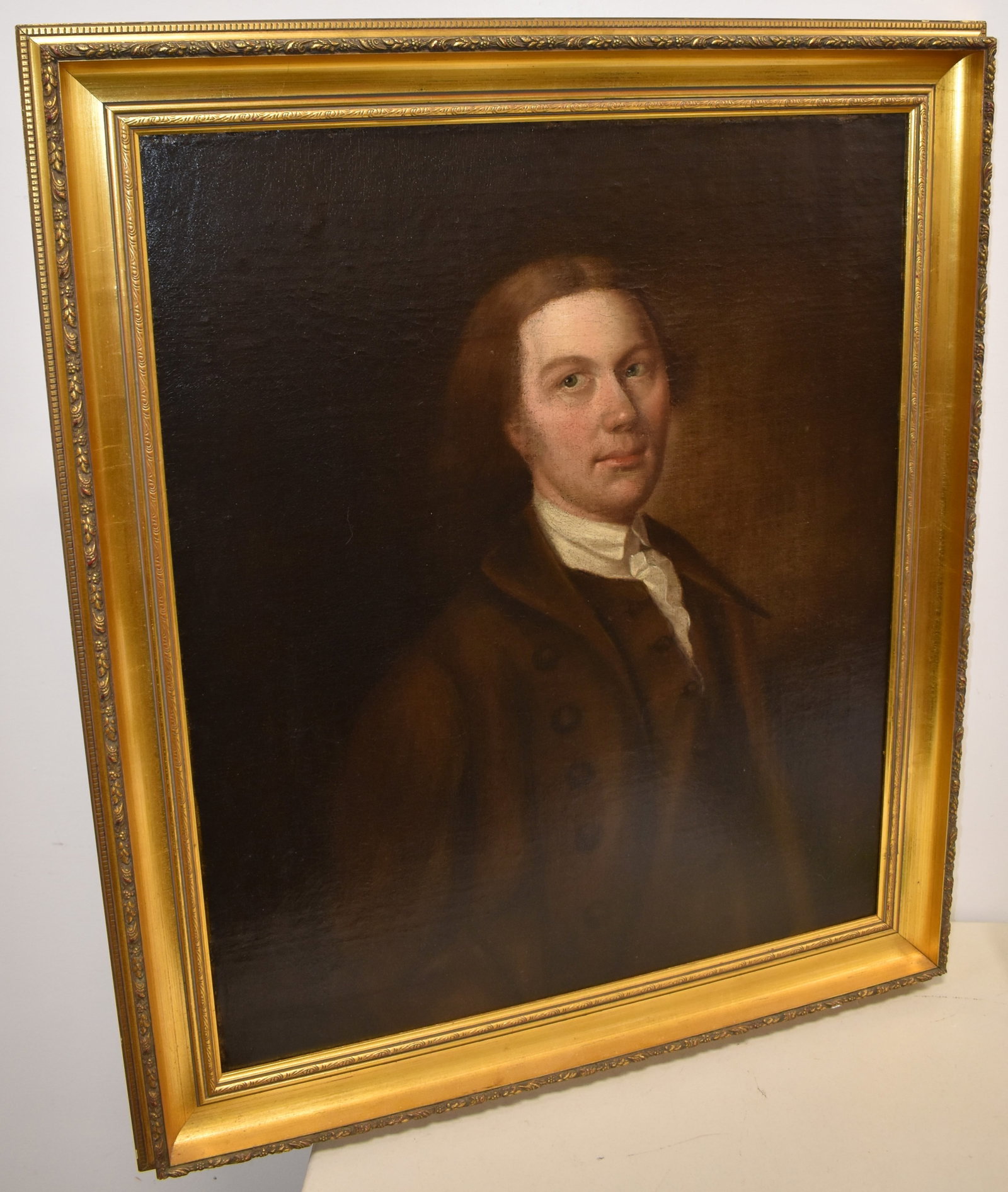 EARLY OIL ON CANVAS PAINTING OF A GENTLEMAN: EARLY 19TH CENT OIL ON CANVAS PORTRIAT OF A YOUNG GENTLEMAN W/ BROWN JACKET & A TUFTED WHITE SHIRT IN A MOLDED GILT WOODEN FRAME - 29 1/2" X 24 1/2" SIGHT - UNSIGNED - IMPERFECTIONS