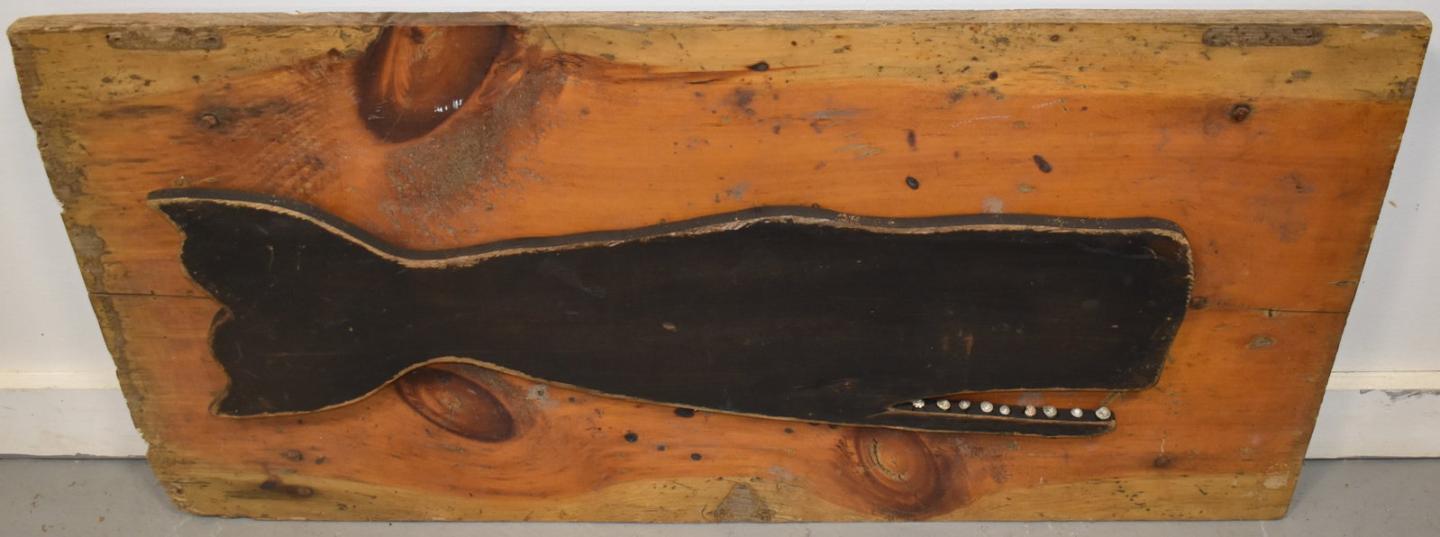 MARTHAS VINEYARD FOLK ART SPERM WHALE WALL PLAQUE: 20TH CENT SPERM WHALE MOUNTED WALL PLAQUE OF A CUT OUT WOODEN PAINTED SPERM WHALE MOUNTED ON OLD WIDE PINE BAORD - SIGNED K. EMACK WELLFLEET MASS ON BACK - WHALE 28 3/4" L - MOUNT 37" L X 18 1/2" W - 