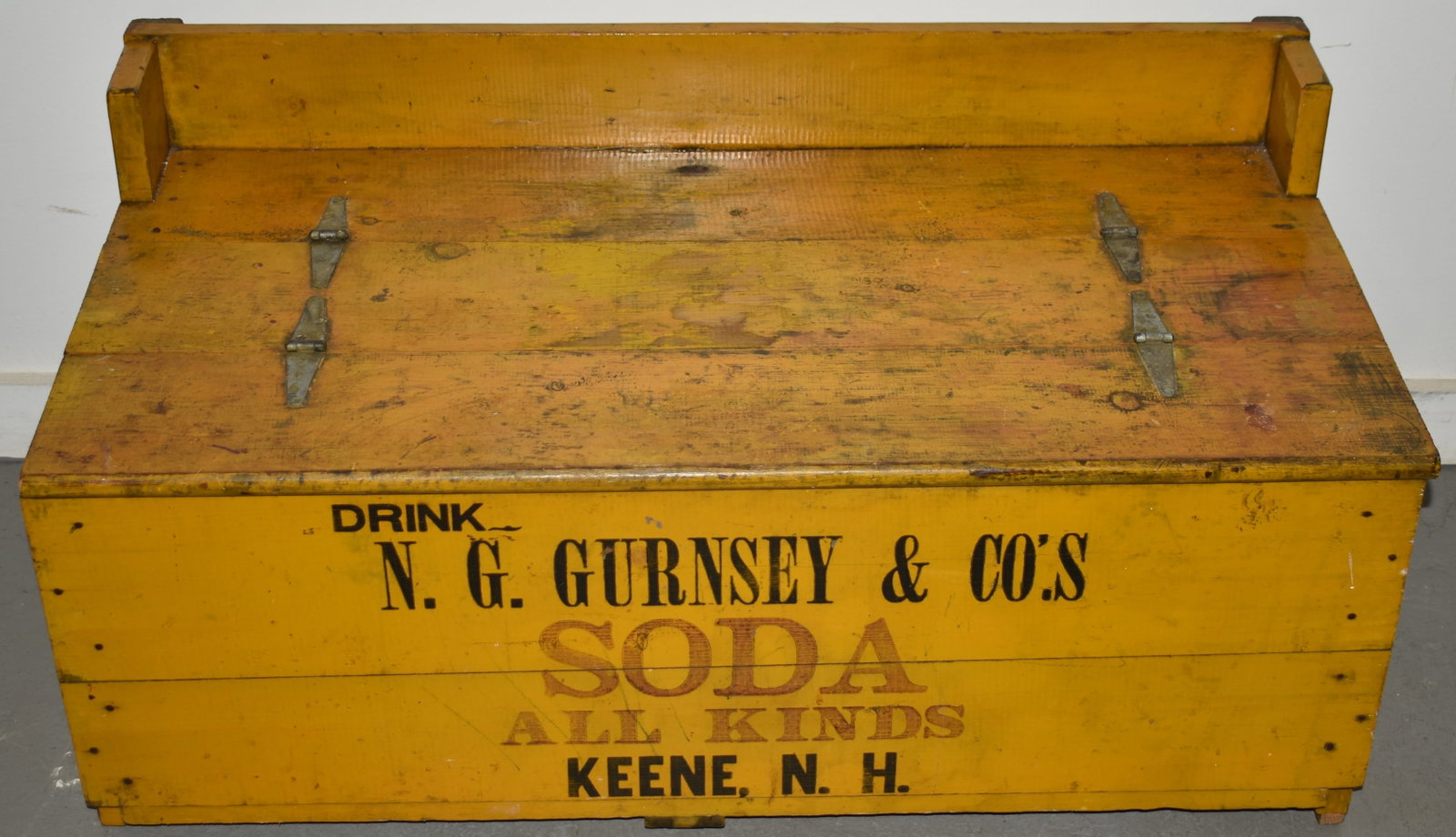 N.G. GURNSEY SODA ADVERTISING WOODEN COOLER: EARLY 20TH CENT PAINTED ZINC LINED SODA COOLER - DRINK N.G. GURNSEY & BROS SODA ALL KINDS KEENE NH - IN OLD MUSTARD PAINT W/ RED & BALCK LETTERING - 19" T X 39 3/4" W X 21" D - POSIBLY MISSING LEGS - 