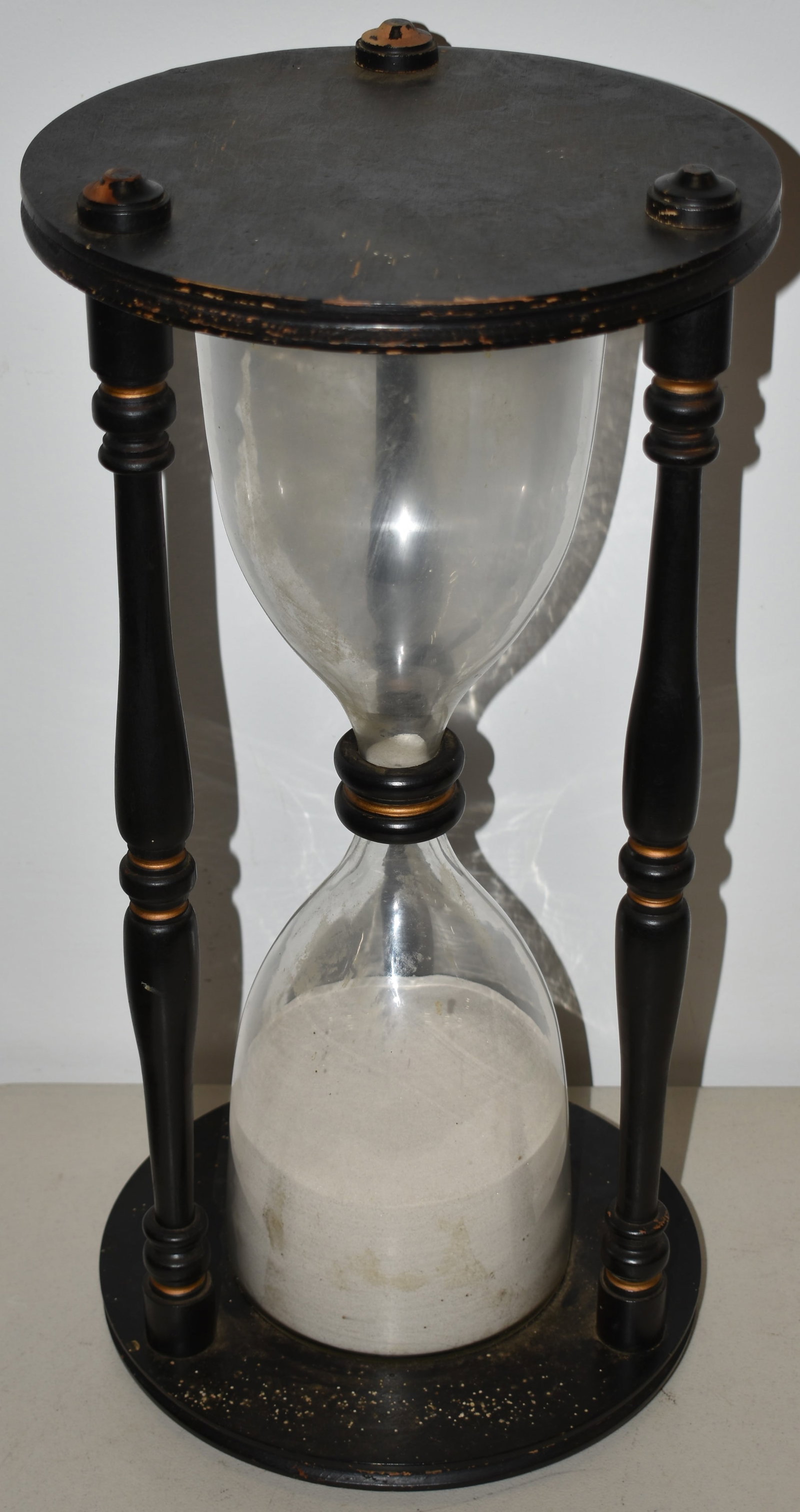 VITNAGE WOODEN HOUR GLASS: EARLY 20TH CENT PAINTED WOODEN HOUR GLASS - 23" T X 11 1/2" DIA - BLACK W/ GOLD GHILIGHTS - WEAR & IMPERFECTIONS