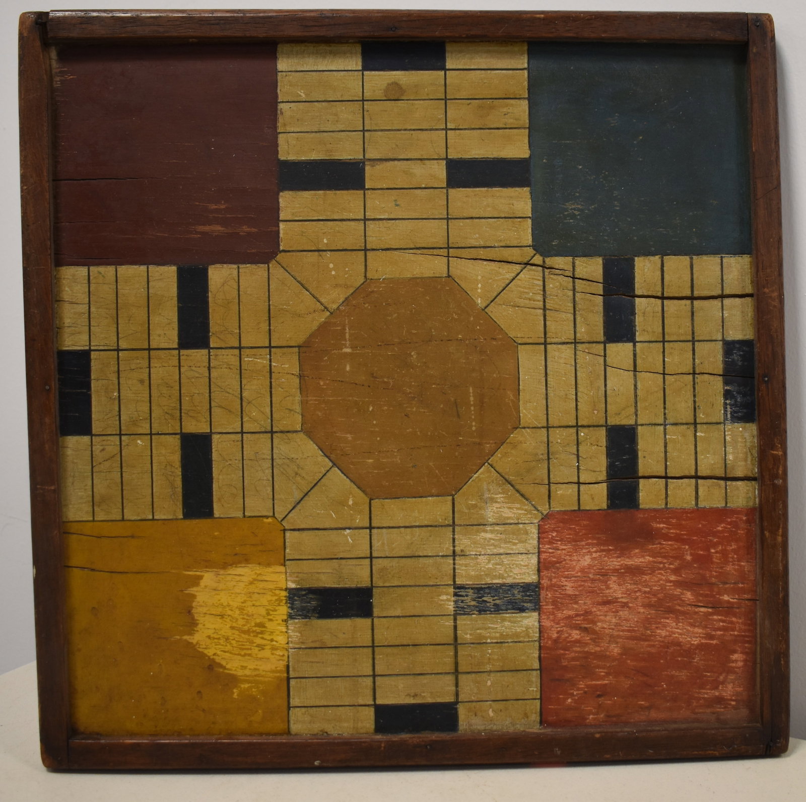DOUBLE SIDED PAINTED WOODEN GAMEBAORD: LATE 19TH EALRY 20TH CENT - FRONT W/ MULTI - COLORED PARCHESSI BOARD - BACK SIDE W/ RED & BURNT YELLOW CHECKER BOARD - 17" SQ. SPLITS, LOSSES & WEAR TO PAINT - IMPERFECTIONS