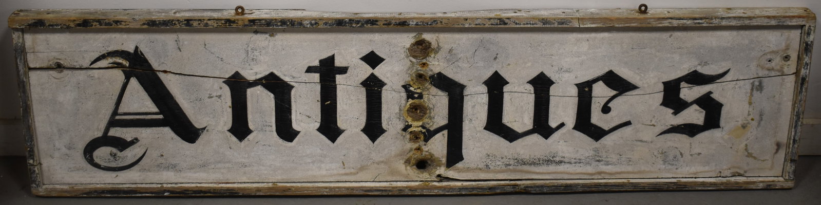PAINTED WOODEN ANTIQUE TRADE SIGN: LATE 19TH EARLY 20TH CENT PAINTED WOODEN SAND PAPER PAINTED SIGN - WHITE W/ BLACK LETTERING - ANTIQUES - 63" X 15" - DOUBLE SIDDED - FRONT SIDE ONLY BLACK PAINTED ANTIQUES - BACK WHITE ON WHITE - SPLI