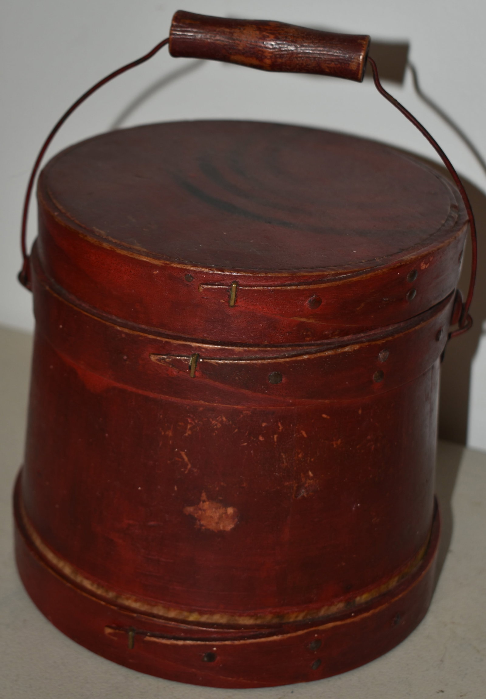 SM. PAINTED WOODEN FINGER BANDED FIRKIN: LATE 19TH CENT PAINTED WOODEN FINGER BANDED FIRKIN IN OLD RED W/ WIRE BAIL W/ TURNED WOODEN HANDLE - 6 3/4" T X 7" D - 9 1/4" W/ HANDLE - WEAR & IMPERFECTIONS