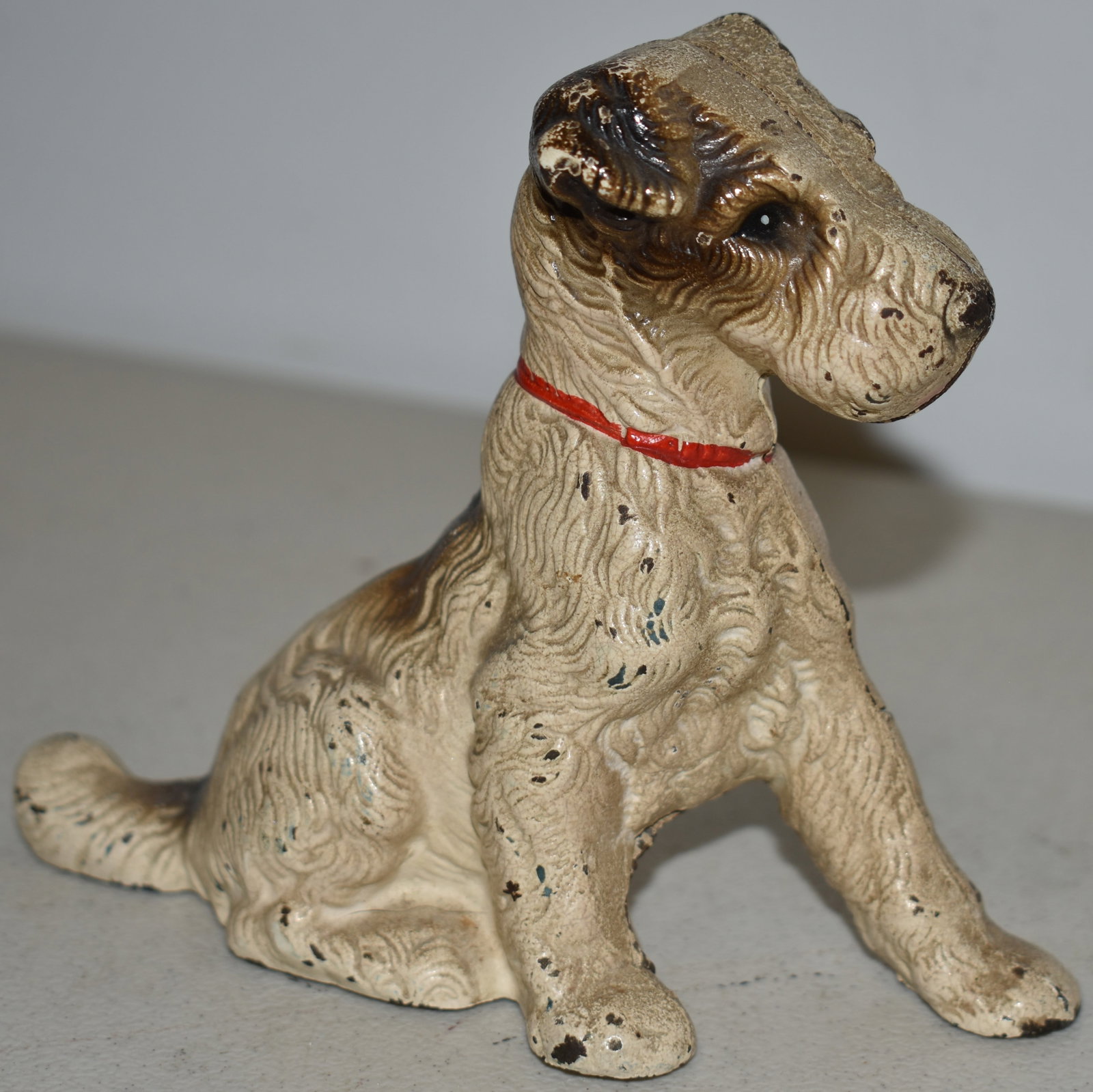 5" PAINTED CAST IRON SEATED DOG COIN BANK: VINTAGE PAINTED CAST IRON COIN BANK OF A SEATED TERRIER - 5" T X 5 1/2" L - WEAR
