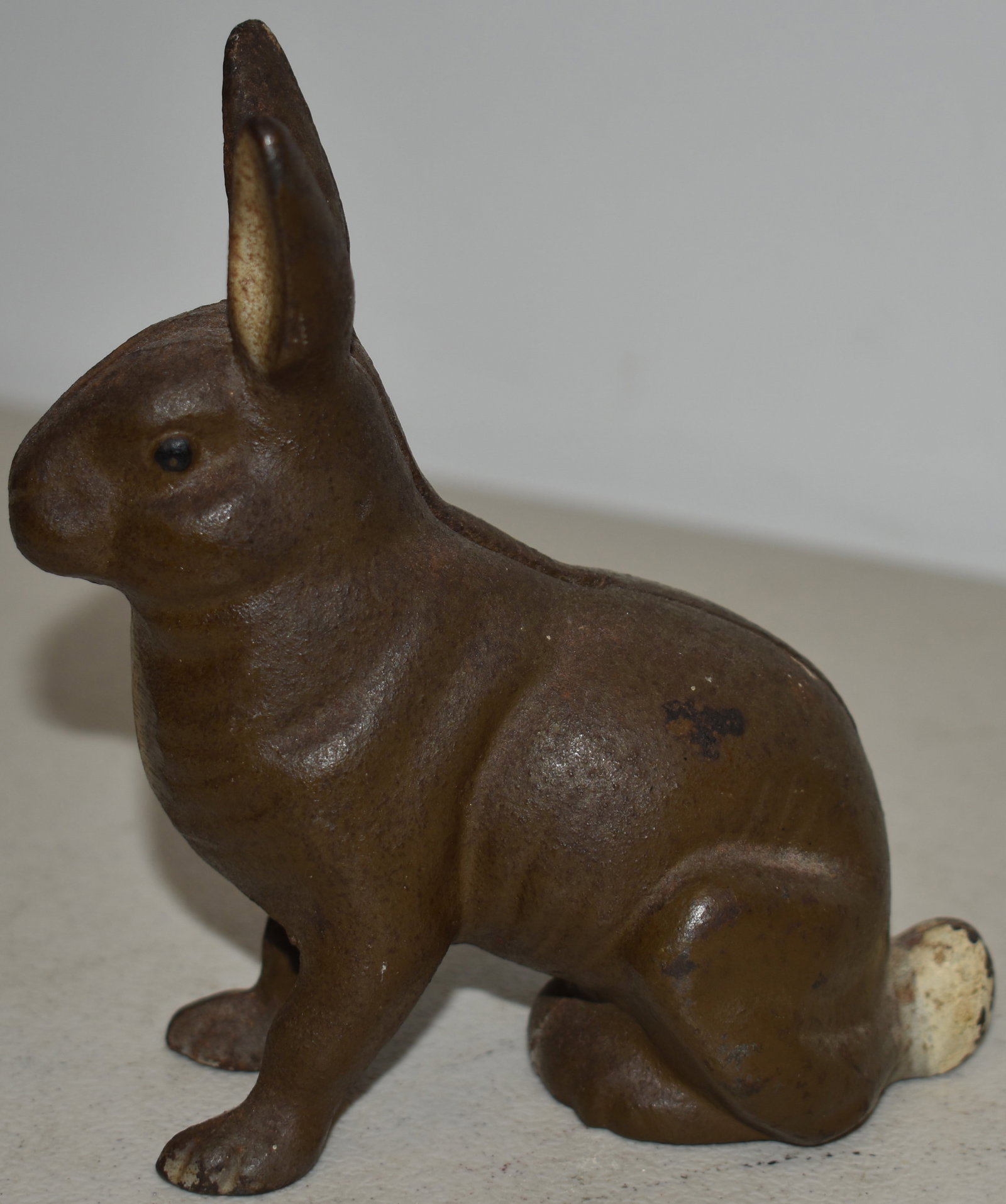 4 1/2" PAINTED CAST IRON SEATED RABBIT COIN BANK: VINTAGE PAINTED CAST IRON COIN BANK OF A SEATED RABBIT - 4 1/2" T X 4" L - WEAR