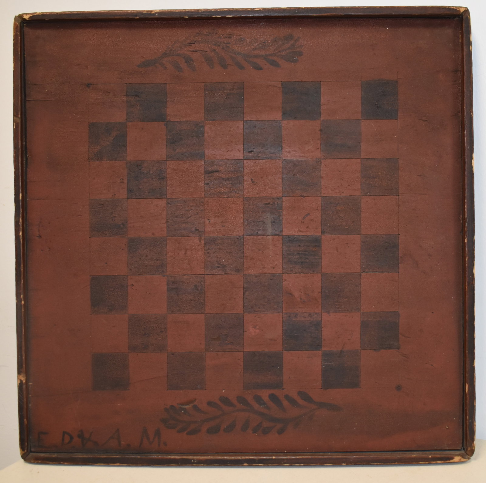 VITNAGE PAINTED WOODEN GAME BOARD: LATE 19TH EARLY 20TH CENT PAINTED PINE GAMEBAORD - CHECKERBOARD IN OLD RED & BLACK - SIGNED E.D.V.A.M LOWER LEFT - 17 3/4" SQ. - DOUBLE SIDED - BACK UNFINISHED? - WEAR & IMPERFECTIONS