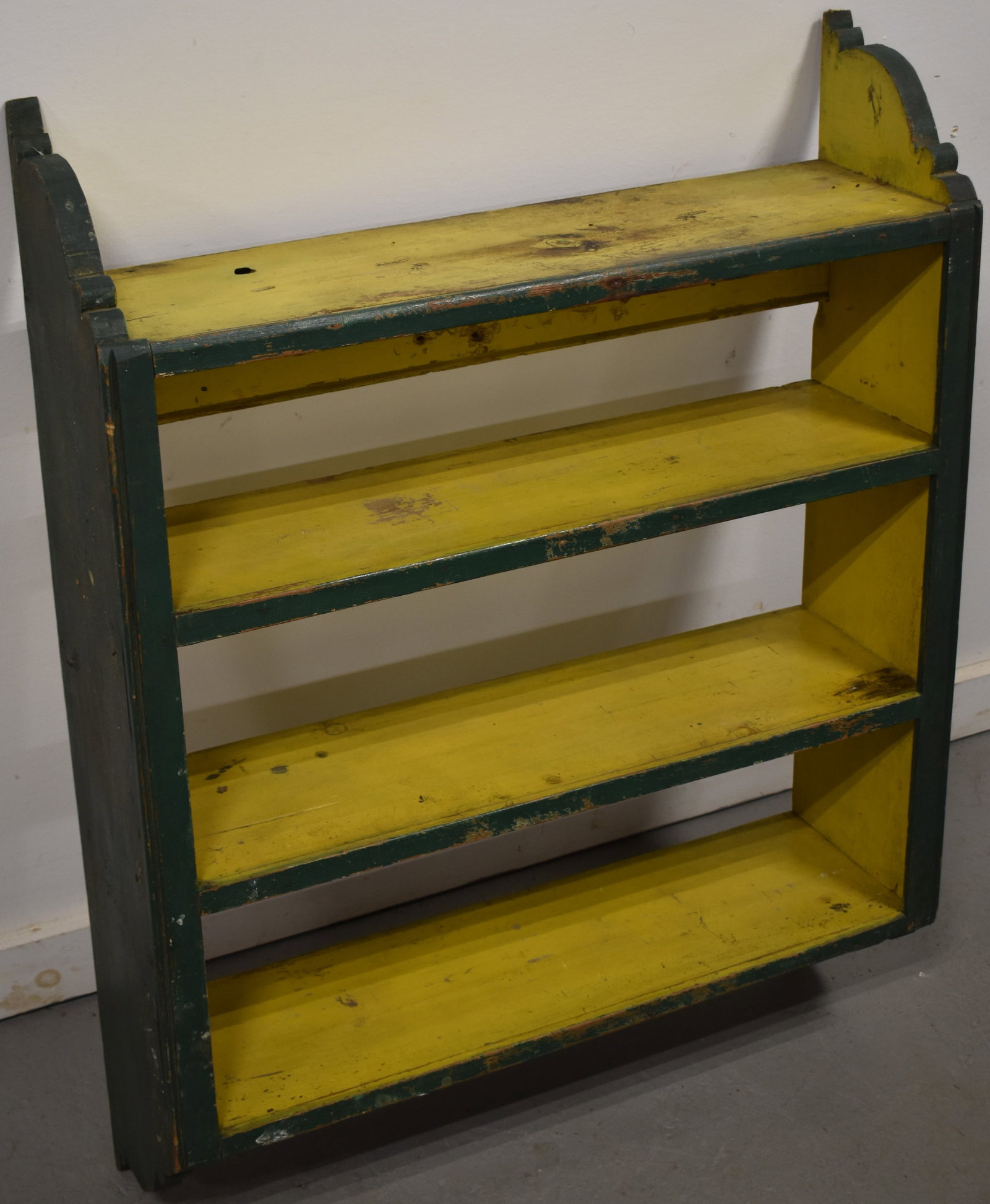 PRIMITIVE PAINTED WOODEN 4 TIER WALL SHELF: EARLY 20TH CENT PAINTED PINE 4 TIER WALL SHELF W. SHAPED SIDES IN OLDER GREEN & YELLOW PAINT - 35 3/4" T X 27 3/4" W X 7 3/4" D - WEAR & IMPERFECTIONS