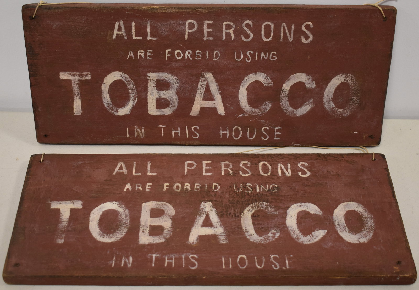(2) PAINTED WOODEN NO SMOKING SIGNS: (2) 20TH CENT PAINTED PINE SIGNS - ALL PERSON ARE FORBID USING TOBACCO IN THIS HOUSE - RED & WHITE LETTERING - 18" X 7 1/2" - WEAR