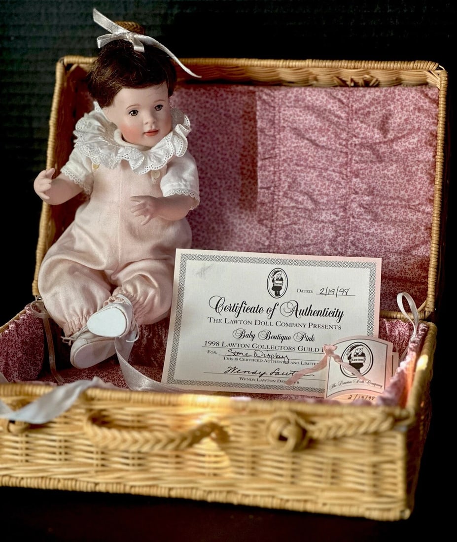 Vintage 1998 Wendy Lawton STORE DISPLAY Baby Boutique Pink 10” Doll: 1998 Wendy Lawton Baby Boutique pink Doll. Created for Store Display. 10” doll by Wendy Lawton.She is all porcelain. Comes in a wicker basket. Her pinky was broken and glued back - see photo. On