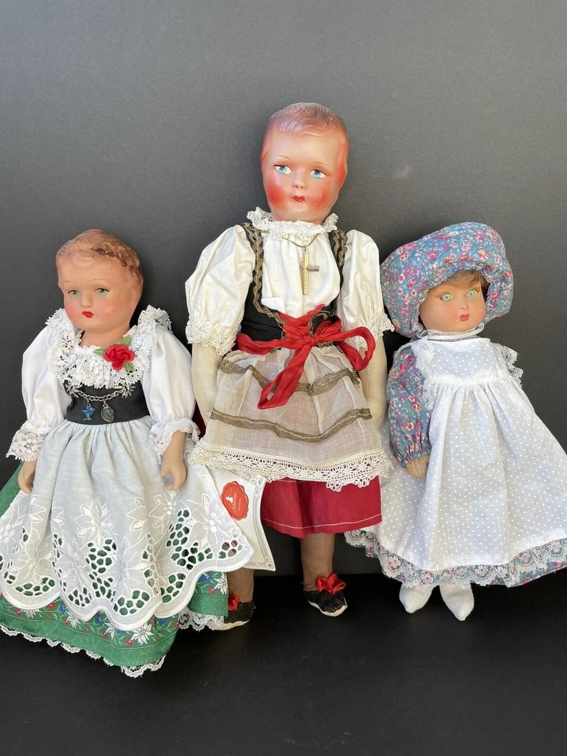 3 Vintage Composition (?) European Dolls. German Schneider Italian F.I.B.A: Very nice collection of vintage dolls. The dolls are 12"-15" tall. One doll is coming with original tag. All 3 dolls have hard heads, but we do not know what they are made of. Looks like the 2 German