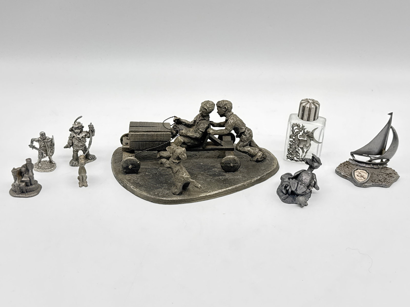 Vintage Pewter Figurine Collection with Drury Soapbox Sculpture (173white): Step into a world of miniature magic with this eclectic lot of vintage pewter figurines and collectibles. Anchoring the collection is a signed International Pewter sculpture by artist Robert Drury, de