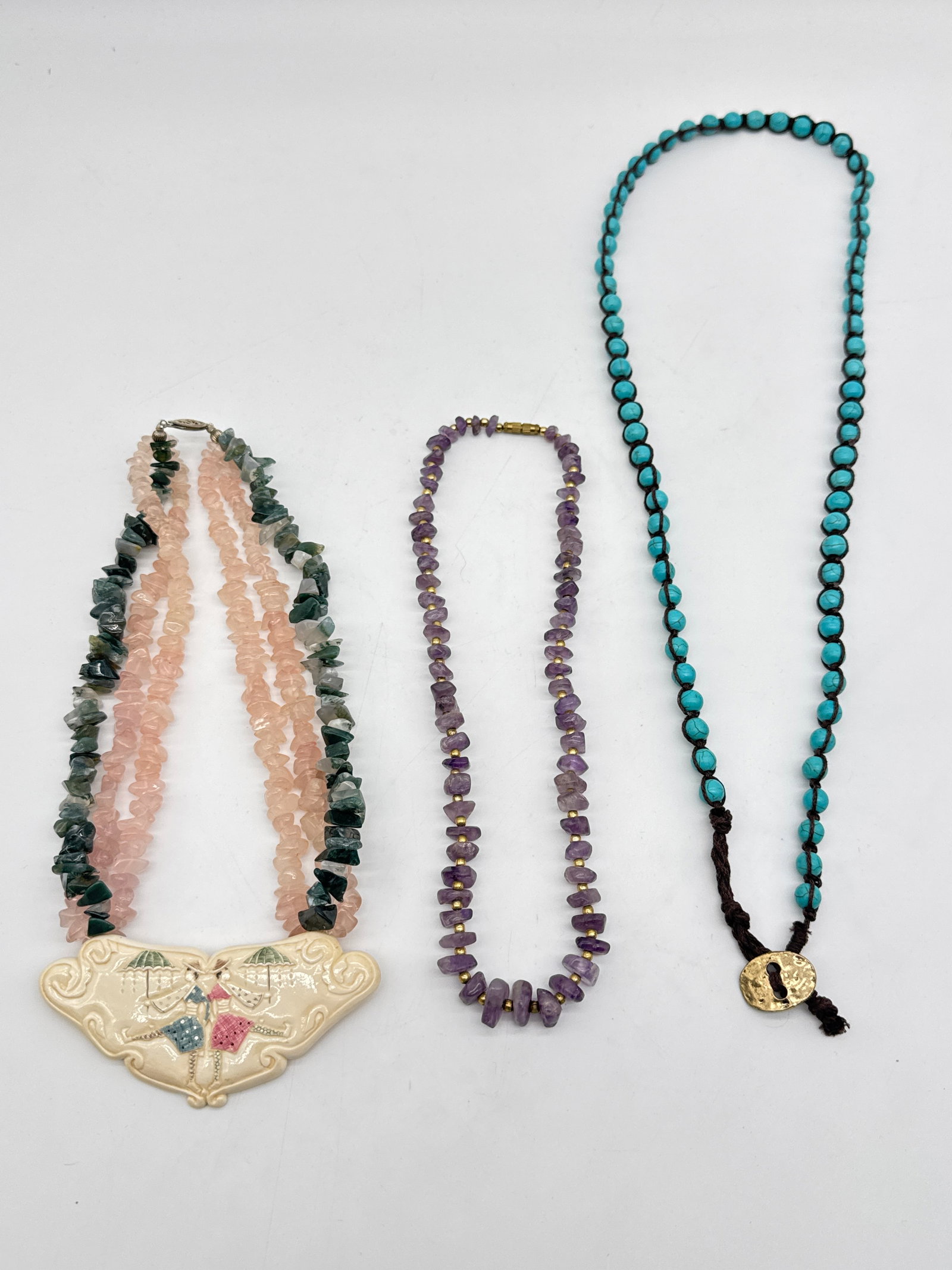 3 Gemstone Necklaces – Rose Quartz, Amethyst, and Faux Turquoise Beads w/ Artistic Pendant186 W: Adorn your spirit and your wardrobe with this eclectic mix of gemstone-inspired necklaces—each radiating its own energy, style, and soul.Rose Quartz & Moss Agate Chip Necklace – This chunky double