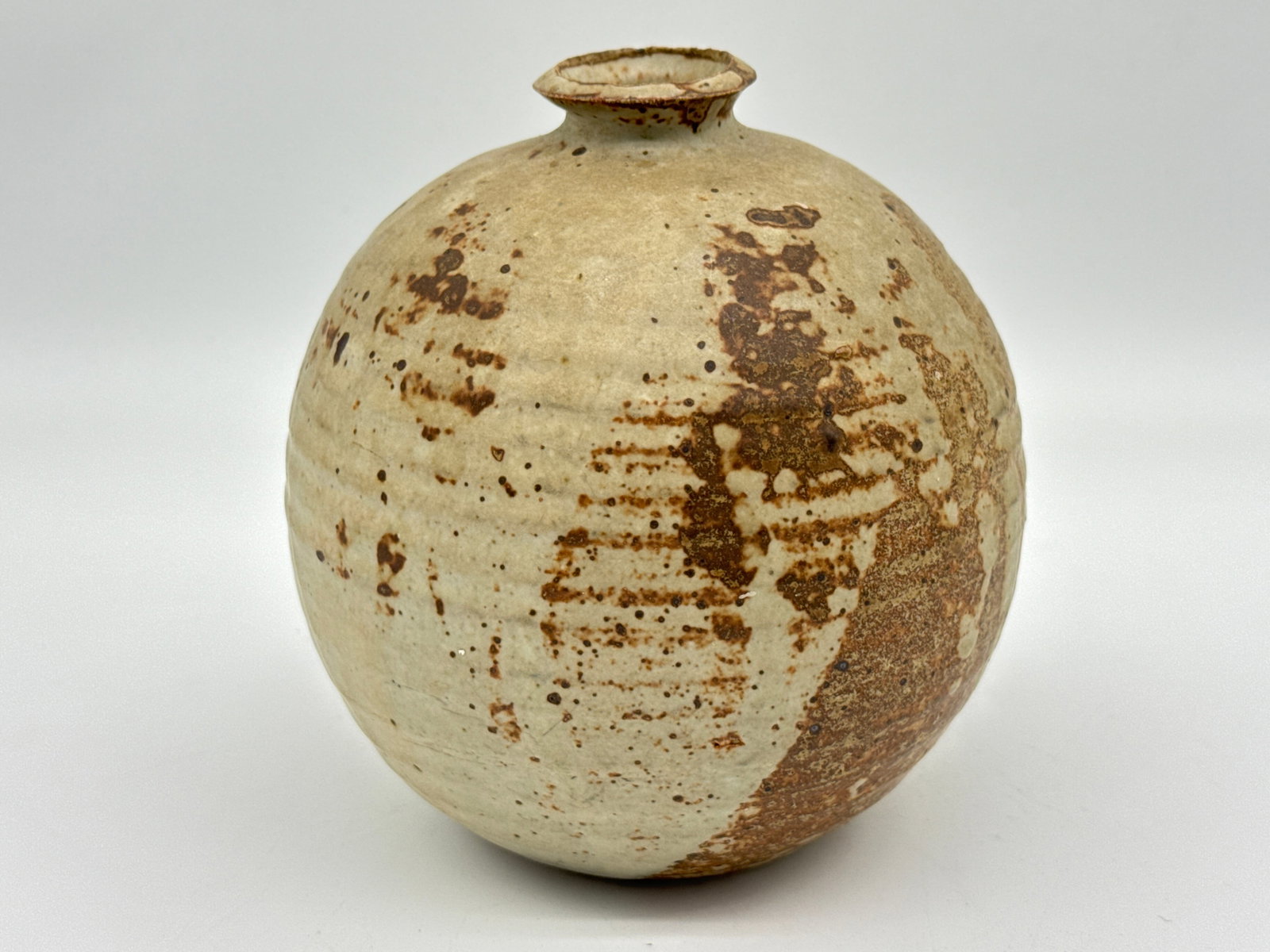 7" Studio Pottery Orb Vase – Rustic Modernist Stoneware with Ash Glaze & Wheel Marks (017 orange): Rough-hewn and radiant, this hand-thrown orb vase blurs the line between ancient artifact and minimalist sculpture—perfect for the collector who values texture, form, and soul.Measuring approximatel