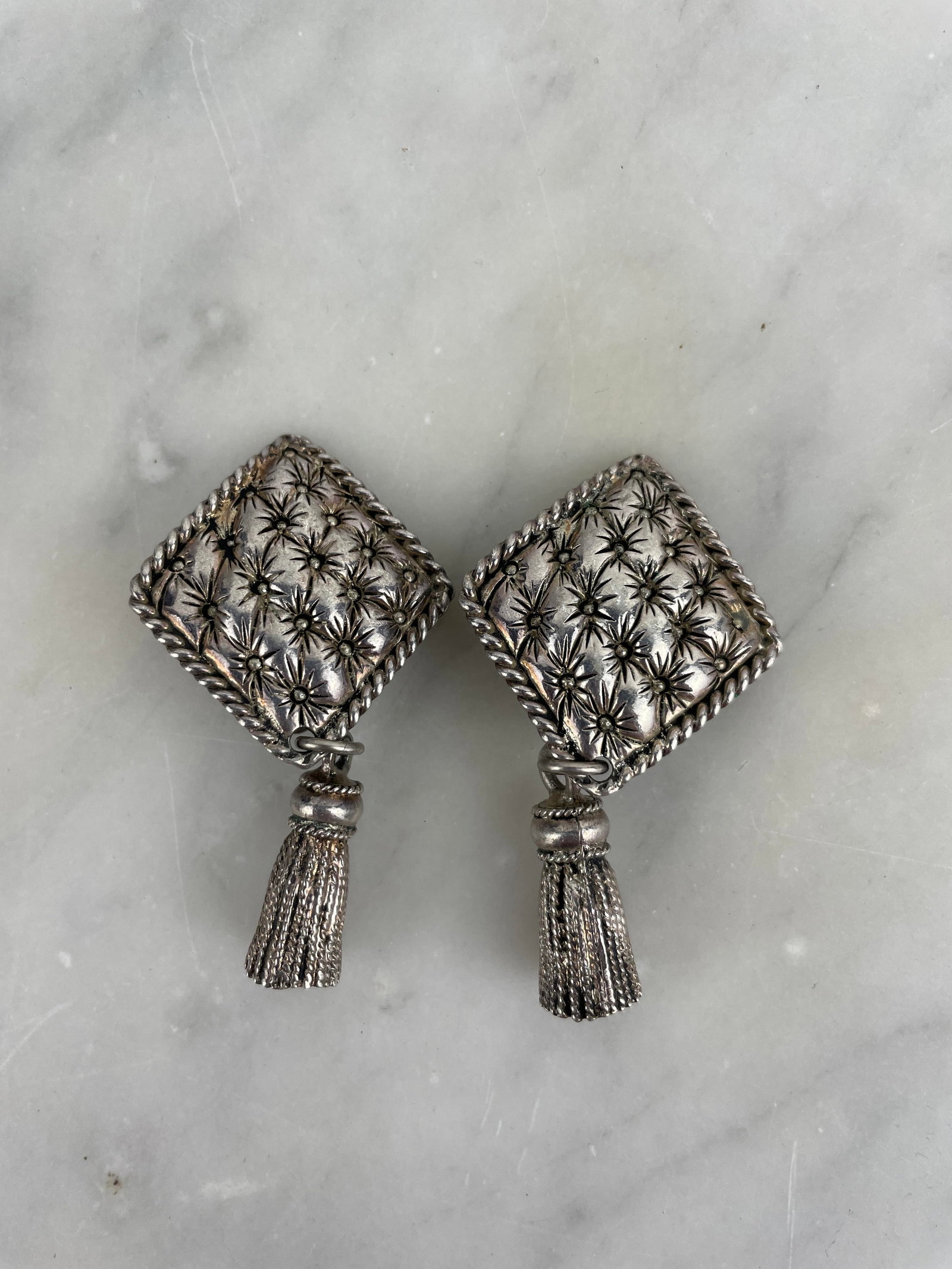 Chantal Thomass - Signed Fancy Clip-On Earrings Pair of satin-finished silver-plated clip-on: Chantal Thomass - Signed Fancy Clip-On Earrings Pair of satin-finished silver-plated clip-on earrings in the shape of rounded diamonds adorned with a raised star motif, highlighted by a twisted outlin