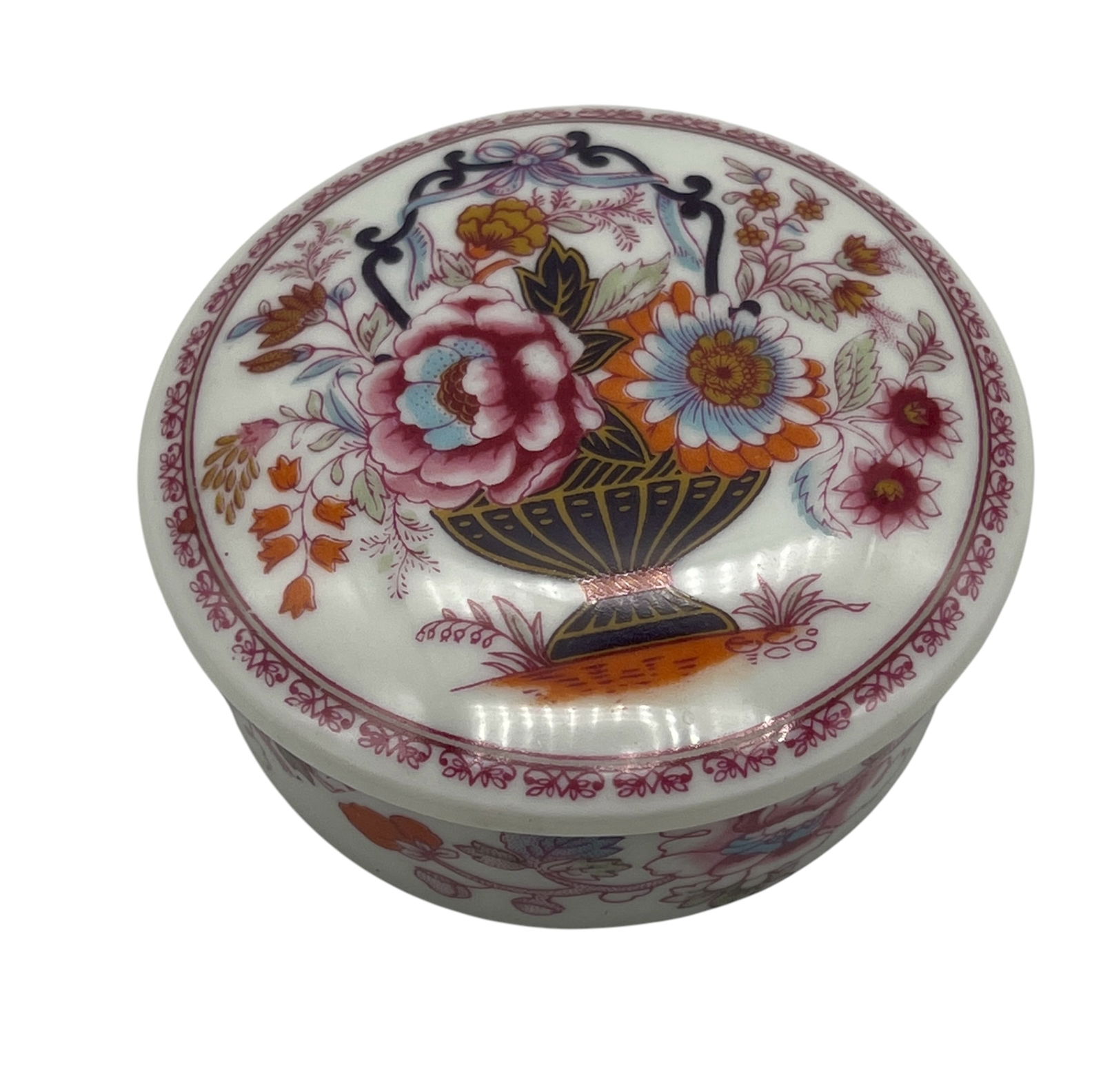 Vintage Limoges Porcelain Trinket Box with Floral Design: A delicate vintage Limoges porcelain trinket box, round in form, featuring a beautifully detailed hand-painted design of a colorful floral bouquet in an urn on the lid, with subtle gilt accents and a