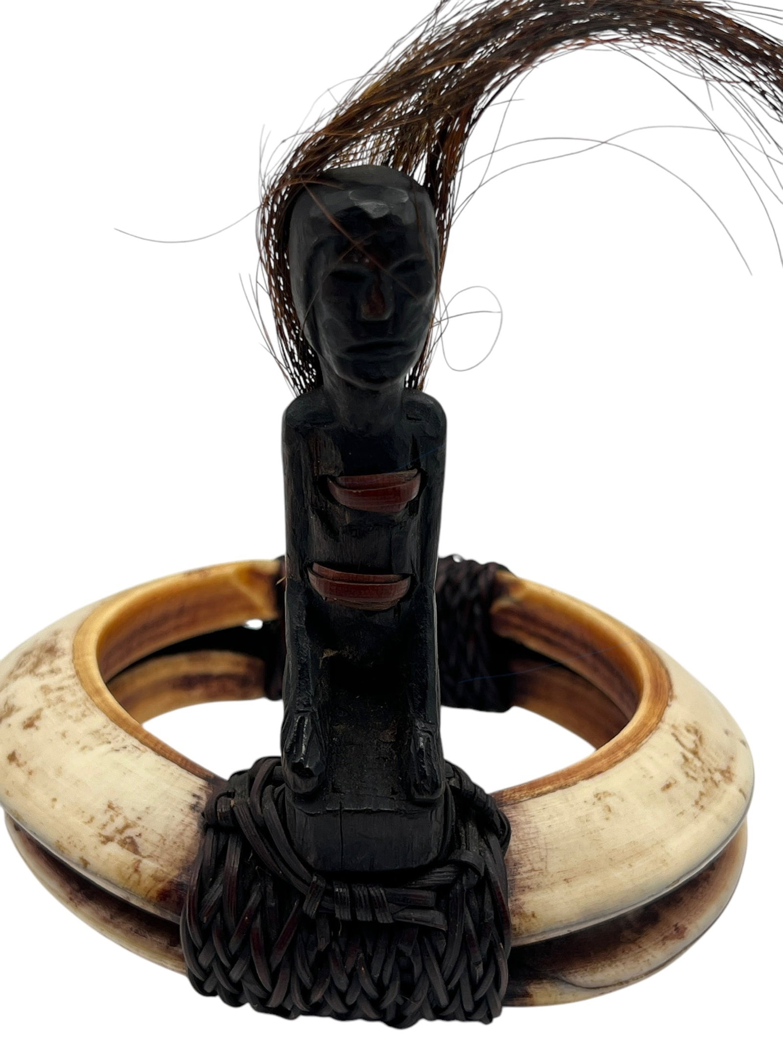 Antique Ifugao Warrior's Armlet (Tangkil) with Human Hair Adornment, Philippines: A rare antique Ifugao "tangkil," a warrior's armlet from the Philippines, crafted from two sections of water buffalo horn bound together with blackened rattan, featuring a carved wooden figure (likely
