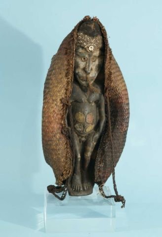 AUSTRAILIAN FERTILITY DOLL WITH WOVEN STRAW HOOD: AUSTRAILIAN FERTILITY DOLL WITH WOVEN STRAW HOOD ON LUCITE BASE. Height: 22 in. by Width: 9 in. by Depth: 6 in.