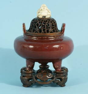 ANTIQUE CHINESE SANG DE BOEUF FOOTED CENSER: FINE ANTIQUE CHINESE SANG DE BOEUF GLAZED EARTHENWARE FOOTED CENSER WITH PIERCED AND CARVED HARDWOOD LID AND BASE; QING DYNASTY, JIAQING-DAOGUANG PERIOD, OR EARLIER OF BULBOUS SLIGHTLY FLATTENED CIRCU