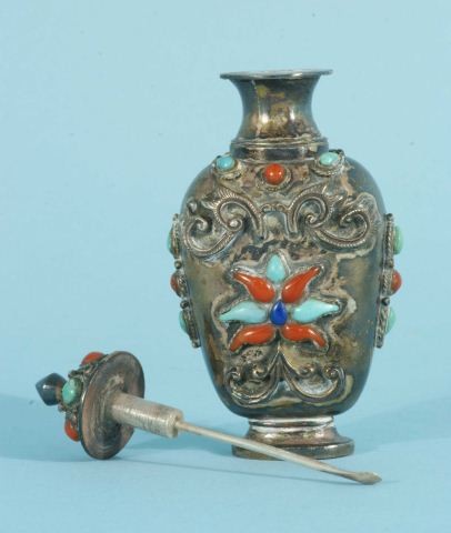 MONGOLIAN BAITONG SILVER METAL SNUFF BOTTLE: VINTAGE MONGOLIAN BAITONG SILVER METAL SNUFF BOTTLE, 1st HALF OF 20th CENTURY, OF TAPERING SLIGHTLY FLATTENED VASE FORM WITH WAISTED OVAL BASE, ORNAMENTED IN RELIEF ON BOTH SIDES AND THE LID WITH CORA
