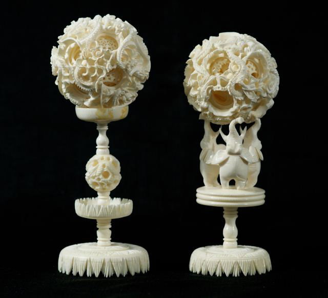 IVORY PUZZLE BALLS WITH DRAGON & ELEPHANT MOTIF: TWO INTRICATELY CARVED IVORY PUZZLE BALLS WITH DRAGON AND ELEPHANT MOTIF ON STANDS. Height: 7 and 7 1/4 in. by Width: 2 3/4 and 2 1/2 in. by Depth: 2 3/4 and 2 1/2 in.
