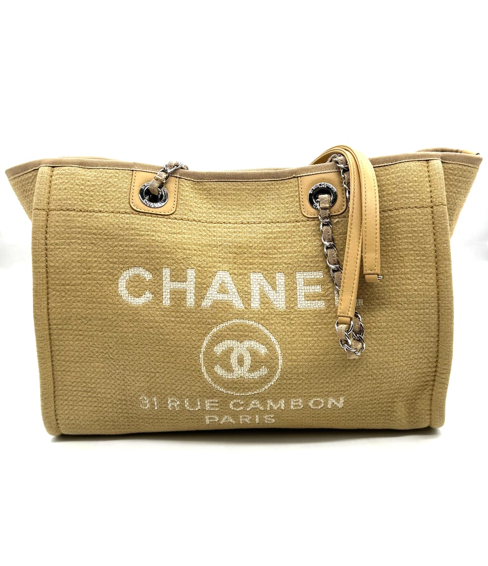Chanel Tote Bag Deauville: Chanel Tote Bag DeauvilleThe Chanel Tote Bag Deauville is a luxurious handbag designed for women. This beige tote features silver hardware, leather and metal handles, and a beige lining. It belongs to
