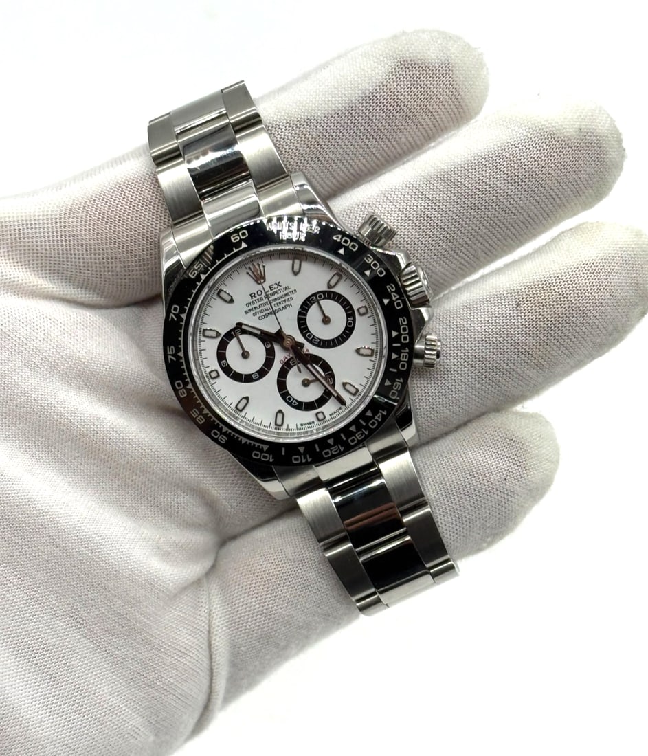 Rolex Cosmograph Daytona White Dial panda Watch 116500LN FULL SET: The Rolex Cosmograph Daytona White Dial "Panda" Watch 116500LN is a luxurious and sporty wristwatch designed for both men and women. Featuring a classic white dial with a black bezel, this Rolex model