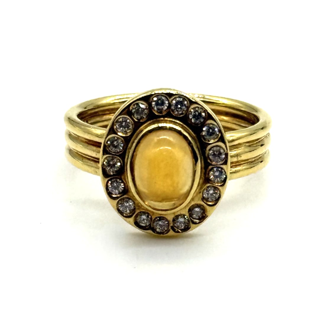 Vintage Tiffany&Co Cabochon and Diamonds 18kt Gold Ring: The Vintage Tiffany & Co. Cabochon and Diamonds 18kt Gold Ring is a luxurious piece of fine jewelry that exudes elegance and sophistication. Featuring a cabochon main stone in a striking white/colorle