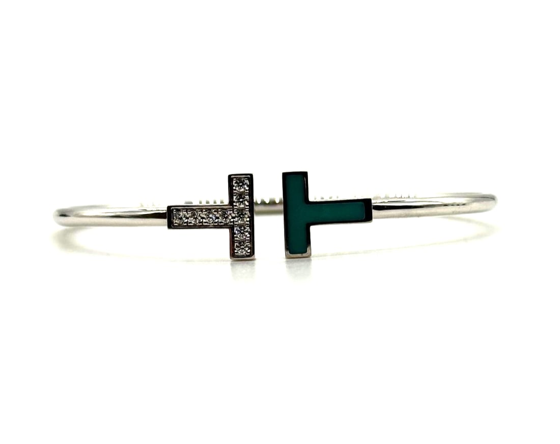 Tiffany & Co 18 Karat White Gold T-Wire Diamond & Turquoise Bangle Bracelet: The Tiffany & Co. 18 Karat White Gold T-Wire Diamond & Turquoise Bangle Bracelet is a stunning piece of fine jewelry that exudes elegance and luxury. Featuring a beautiful turquoise stone set in white