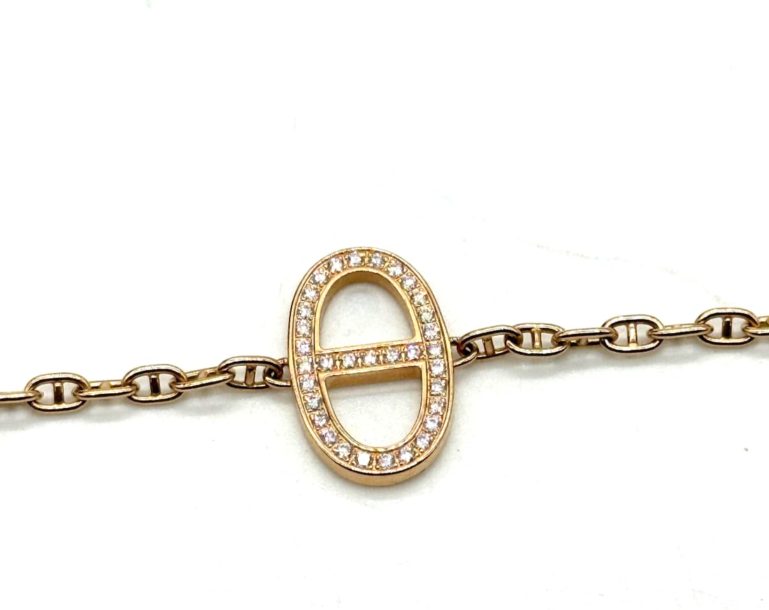Hermes 18Kt Rose Gold Diamond Chaine d'ancre Contour bracelet: The Hermes 18Kt Rose Gold Diamond Chaine d'ancre Contour bracelet is a luxurious and elegant piece of fine jewelry. Made from high-quality 18k rose gold, this chain bracelet features a stunning pink d