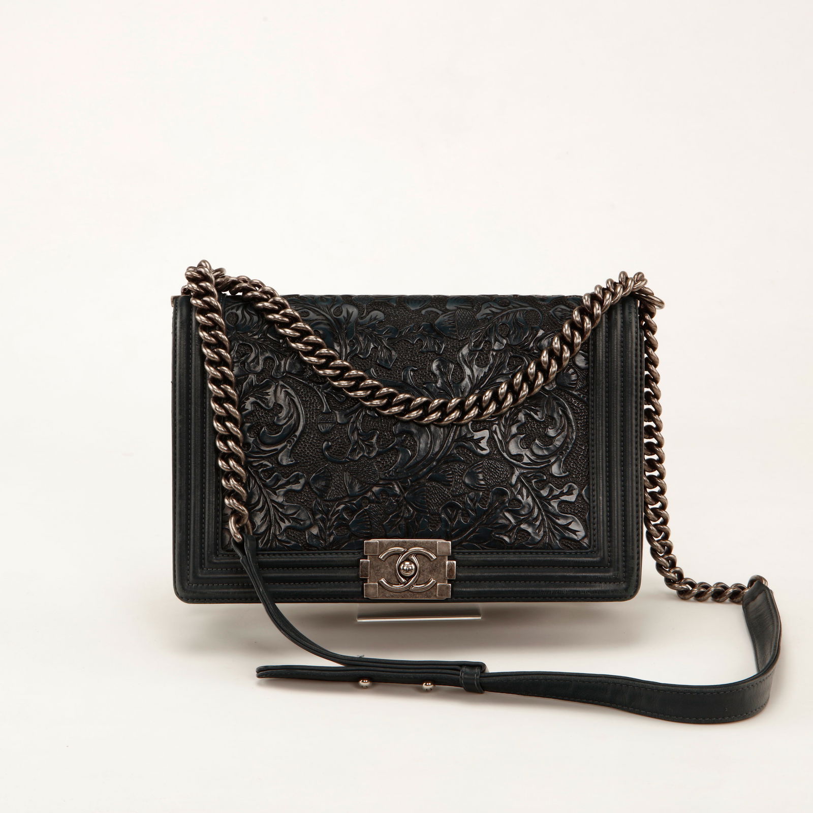 Chanel Boy Bag Embossed Floral Leather Shoulder Bag – Dark Blue with Ruthenium Hardware: Chanel Boy flap bag crafted in dark blue embossed leather featuring an intricate floral motif. The structured silhouette is framed with tonal leather trim and finished with the iconic Boy push-lock cl
