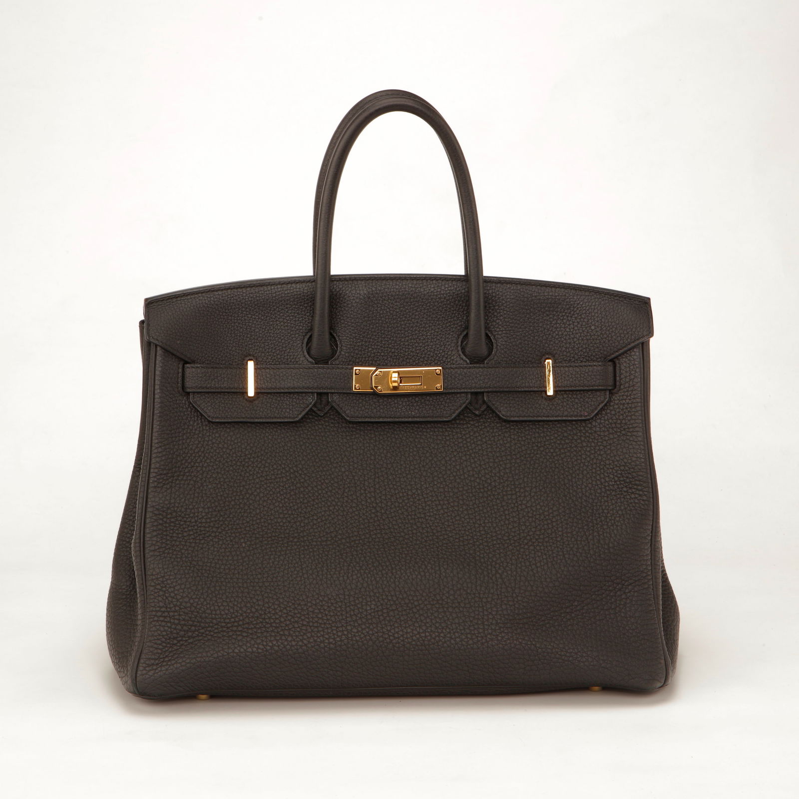 Hermès Birkin 35 Togo Leather Handbag – with Gold Hardware: Authentic Hermès Birkin 35 crafted in luxurious grained Togo leather in the sophisticated Etain grey shade. Accented with rich gold-plated hardware, this iconic design features the signature front fl