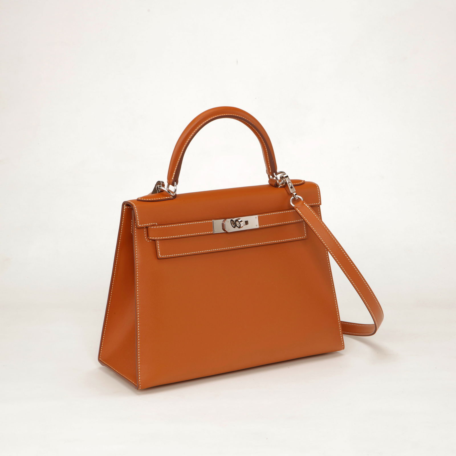 Hermès Kelly 28 Swift Leather Sellier Handbag – Gold with Palladium Hardware: Authentic Hermès Kelly 28 crafted in smooth Swift leather in the iconic Gold shade, accented with crisp contrast stitching and palladium-plated hardware. Designed in the structured Sellier style, thi