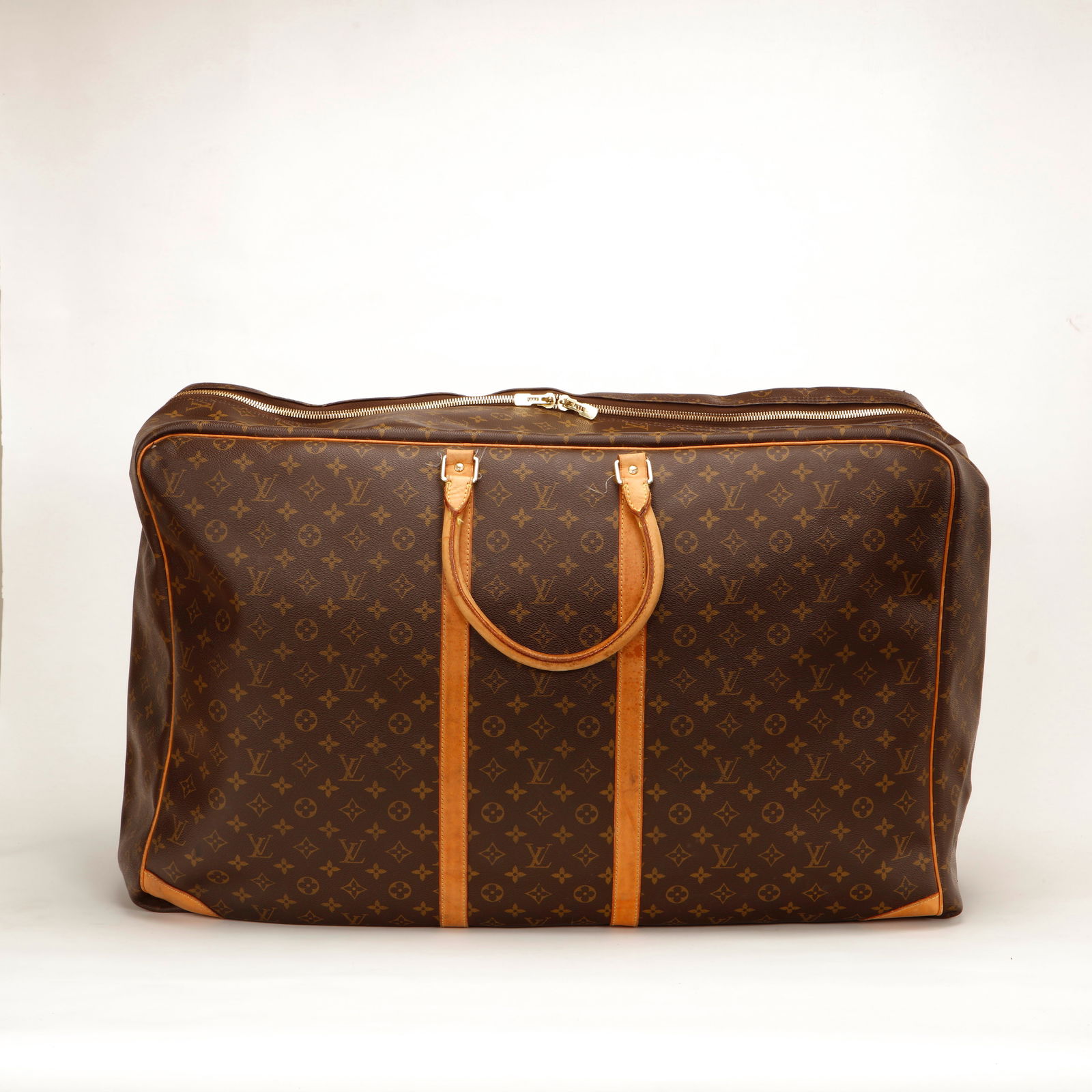 Louis Vuitton Monogram Sirius 55 Soft Travel Bag: Authentic Louis Vuitton Sirius 55 crafted in iconic Monogram canvas with natural cowhide leather trim and gold-tone hardware. This spacious soft-sided travel bag features double rolled leather