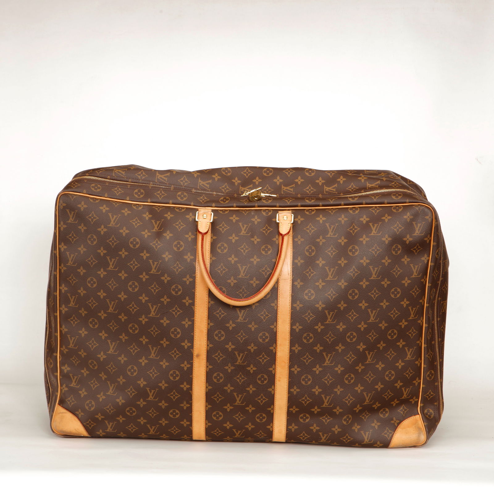 Louis Vuitton Monogram Sirius 60 Travel Bag: Authentic Louis Vuitton Sirius 60 crafted in iconic Monogram canvas with natural cowhide leather trim and gold-tone hardware. This soft-structured travel bag features double rolled leather handles,