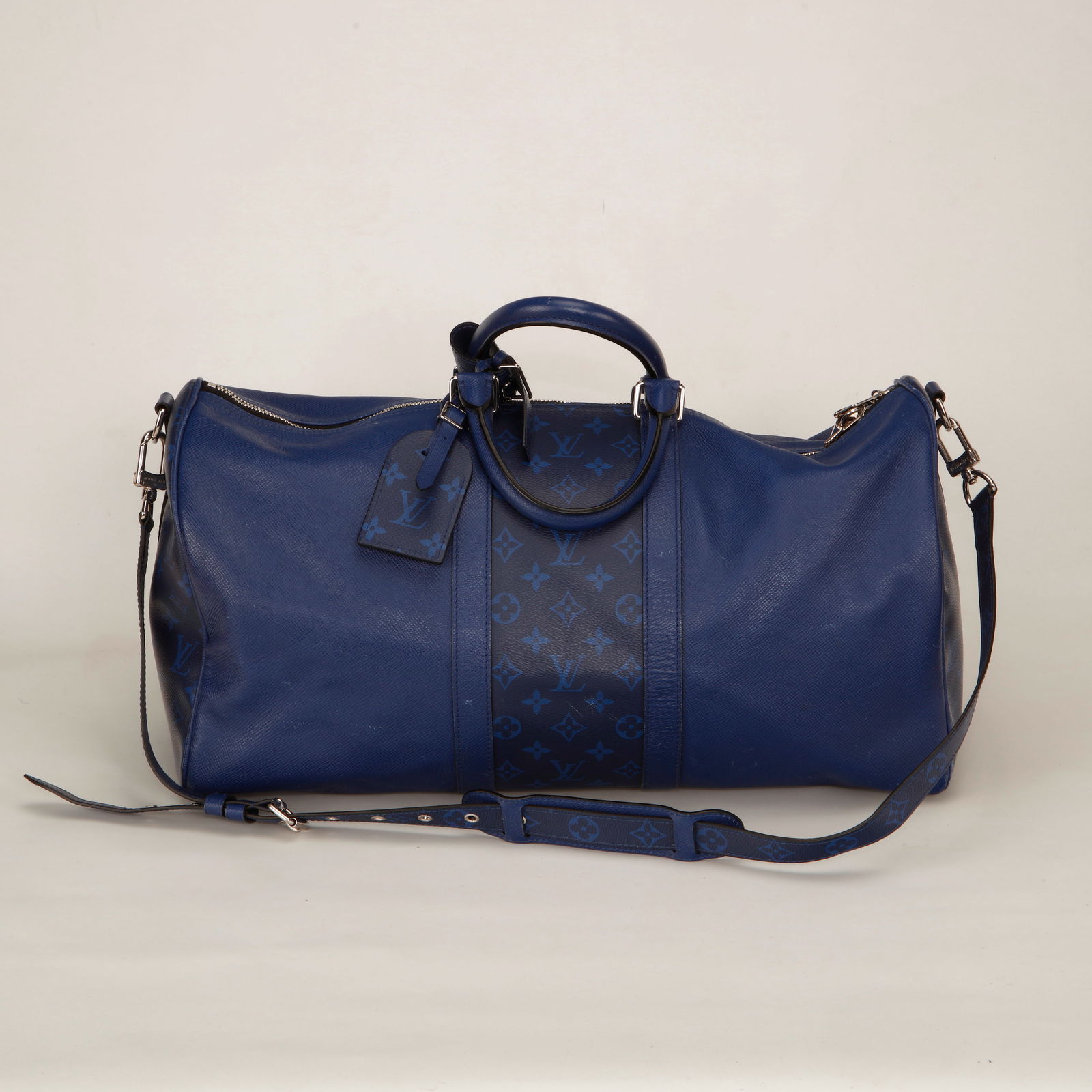 Louis Vuitton Keepall Bandoulière 50 Taïga & Monogram Ink Leather – Blue: Authentic Louis Vuitton Keepall Bandoulière 50 crafted in rich blue Taïga leather with a matching Monogram Ink leather central panel. This modern interpretation of the classic Keepall features