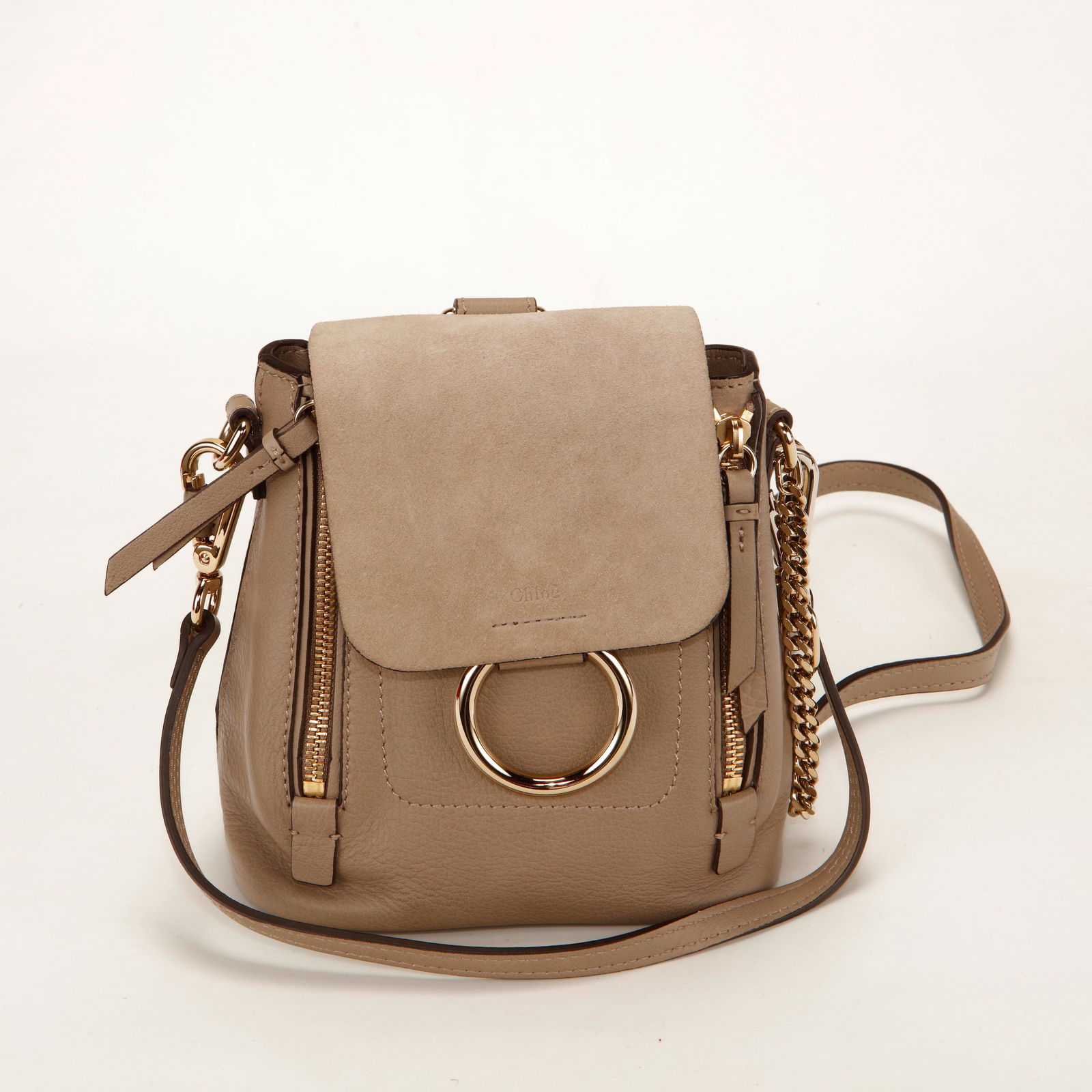 Chloé Faye Mini Backpack – Beige Leather & Suede: Authentic Chloé Faye Mini Backpack crafted in smooth beige leather with a suede flap and gold-tone hardware. This compact silhouette features the signature oversized metal ring and chain detail at