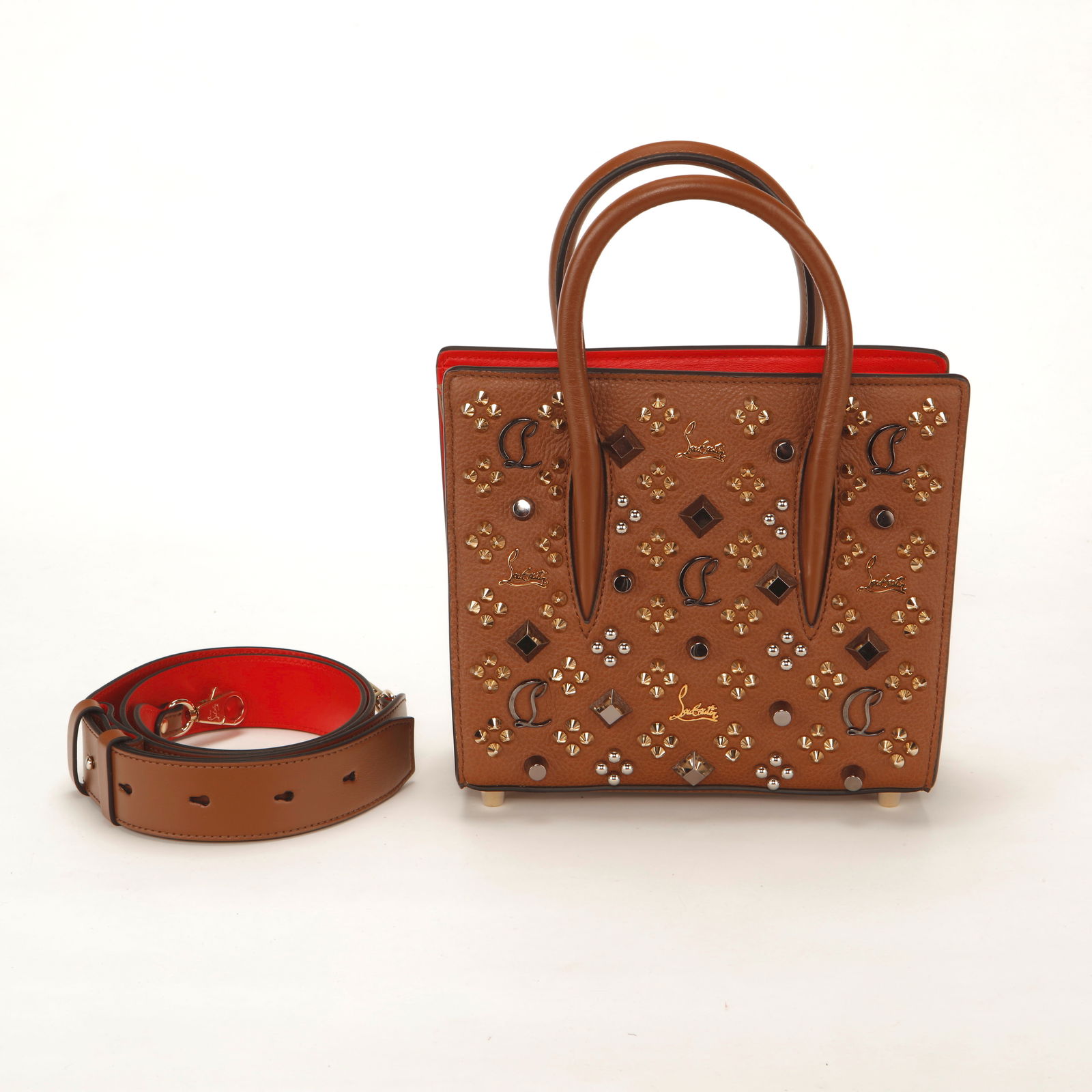 Christian Louboutin Paloma Small Studded Leather Tote: Christian Louboutin Paloma Small tote crafted in brown grained leather, embellished with mixed metal studs, signature CL monogram hardware, and geometric crystal accents. Features structured top handl