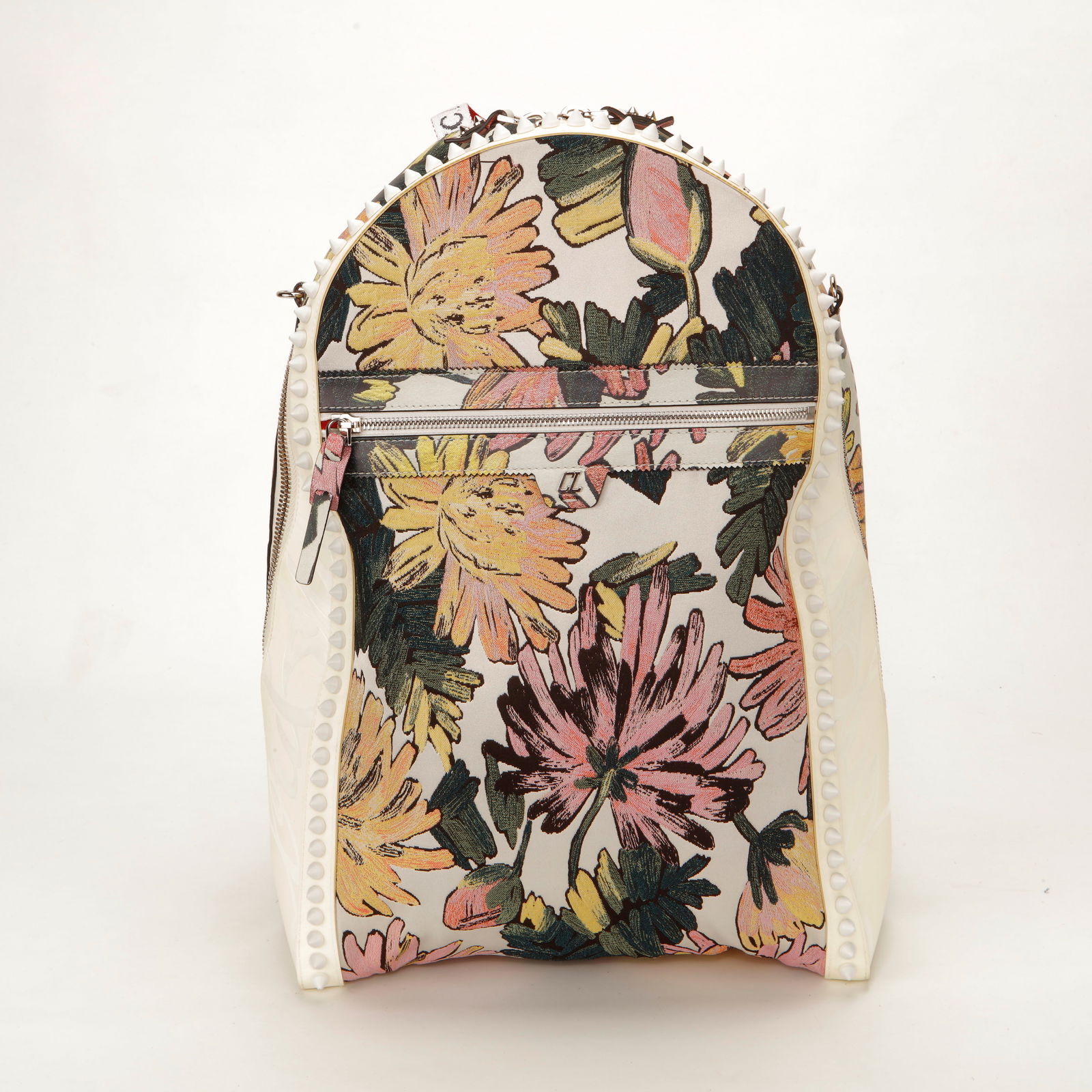 Christian Louboutin Floral Canvas Stud Trim Backpack: Christian Louboutin backpack crafted in floral printed canvas with smooth tonal leather side panels and signature spike trim outlining the silhouette. Designed with a structured rounded shape, top han