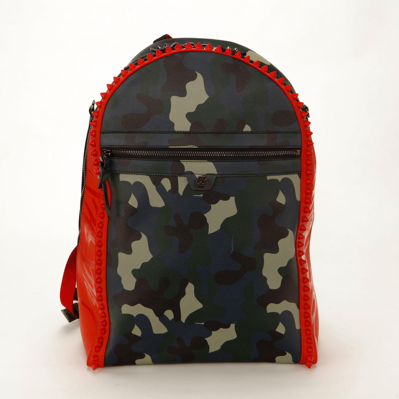 Christian Louboutin Backparis Reporter Camo Backpack: Christian Louboutin Backpapris backpack crafted in camouflage printed leather with signature red rubberized side panels and spike trim framing the silhouette. Features a structured dome shape, front z