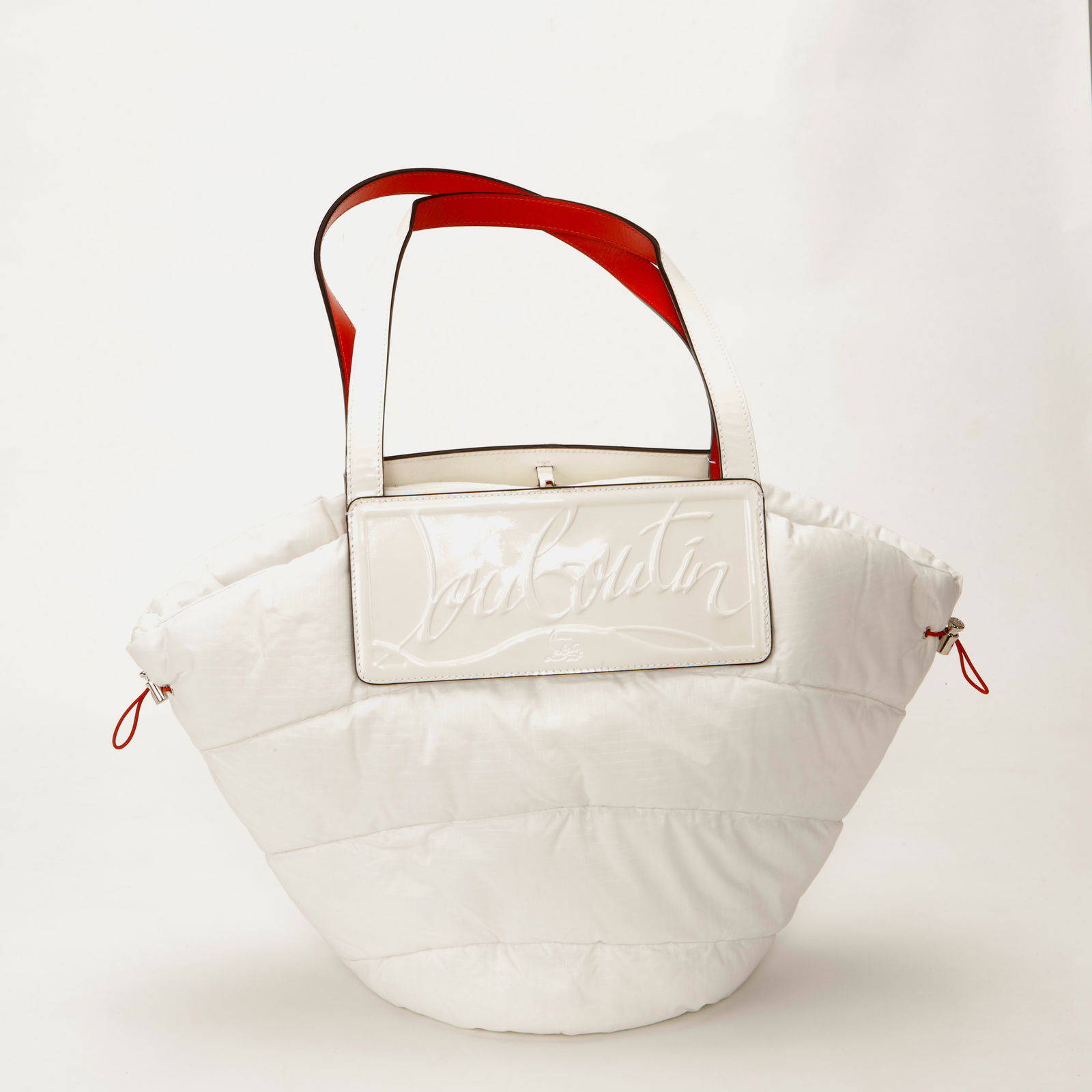 Christian Louboutin Loubishore Puffer Tote Bag: Christian Louboutin Loubishore tote crafted in quilted white technical fabric with an oversized silhouette. Features a glossy embossed “Louboutin” logo plaque across the front, wide shoulder s