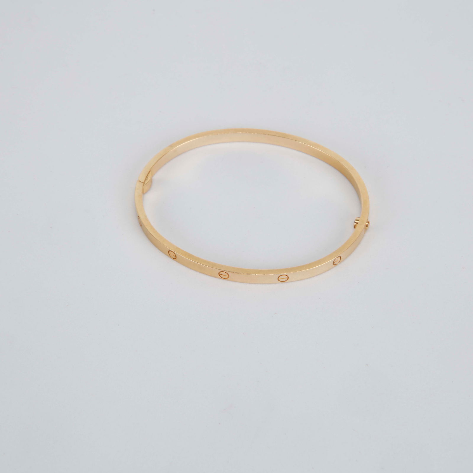 Cartier Love small Bracelet Size 18 – 18K Yellow Gold: Cartier Love small bracelet crafted in 18K yellow gold featuring the iconic engraved screw motif along the classic slim bangle silhouette. Designed with the signature locking closure system, this time
