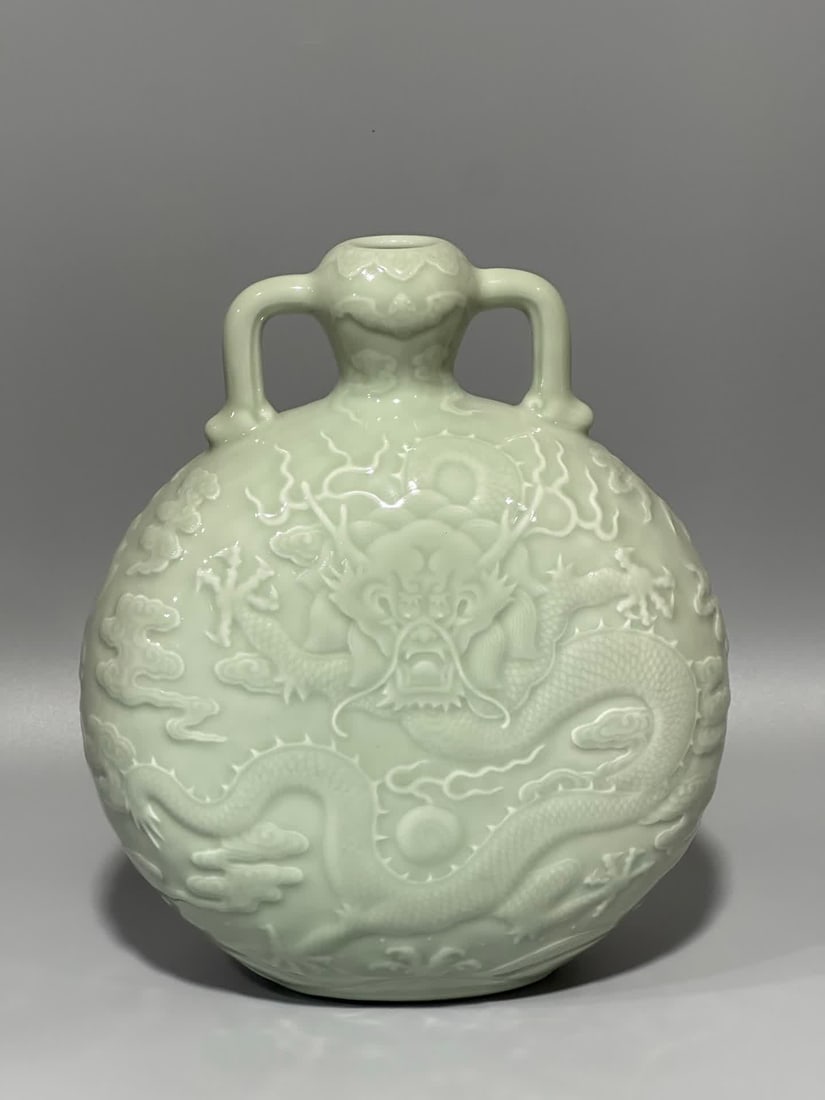 A Qing Dynasty Qianlong year bean celadon embossed dragon pattern amphora flat bottle: Qing Dynasty Qianlong year bean celadon embossed dragon pattern amphora flat bottle SIZE: H: 23cm MouthD: 2.7cm Belly diameter 21cm bottom 9cm