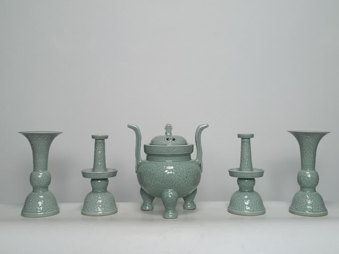 A set of Qing Qianlong model bean celadon carved entwined lotus patterns: Qing Qianlong model bean blue glaze carved entwined lotus pattern five sets of offerings SIZE: Incense burner H: 32cm W: 29cm Candlestick H: 28.3cm W: 13.8cm Flower cup H: 29cm W: 15.2cm (The Dimensio
