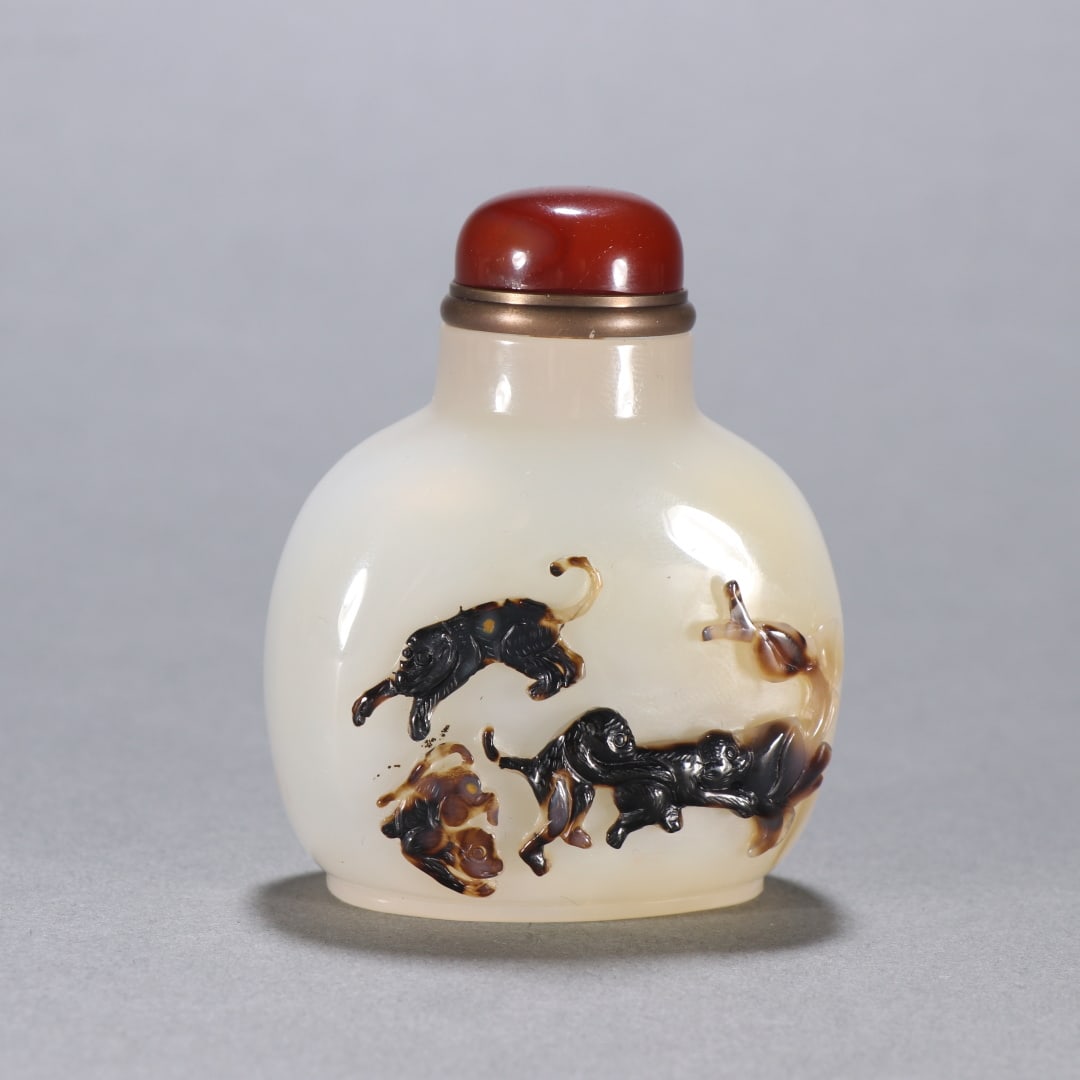A Qing Dynasty agate carved spirit monkey birthday snuff bottle (1 of 9)