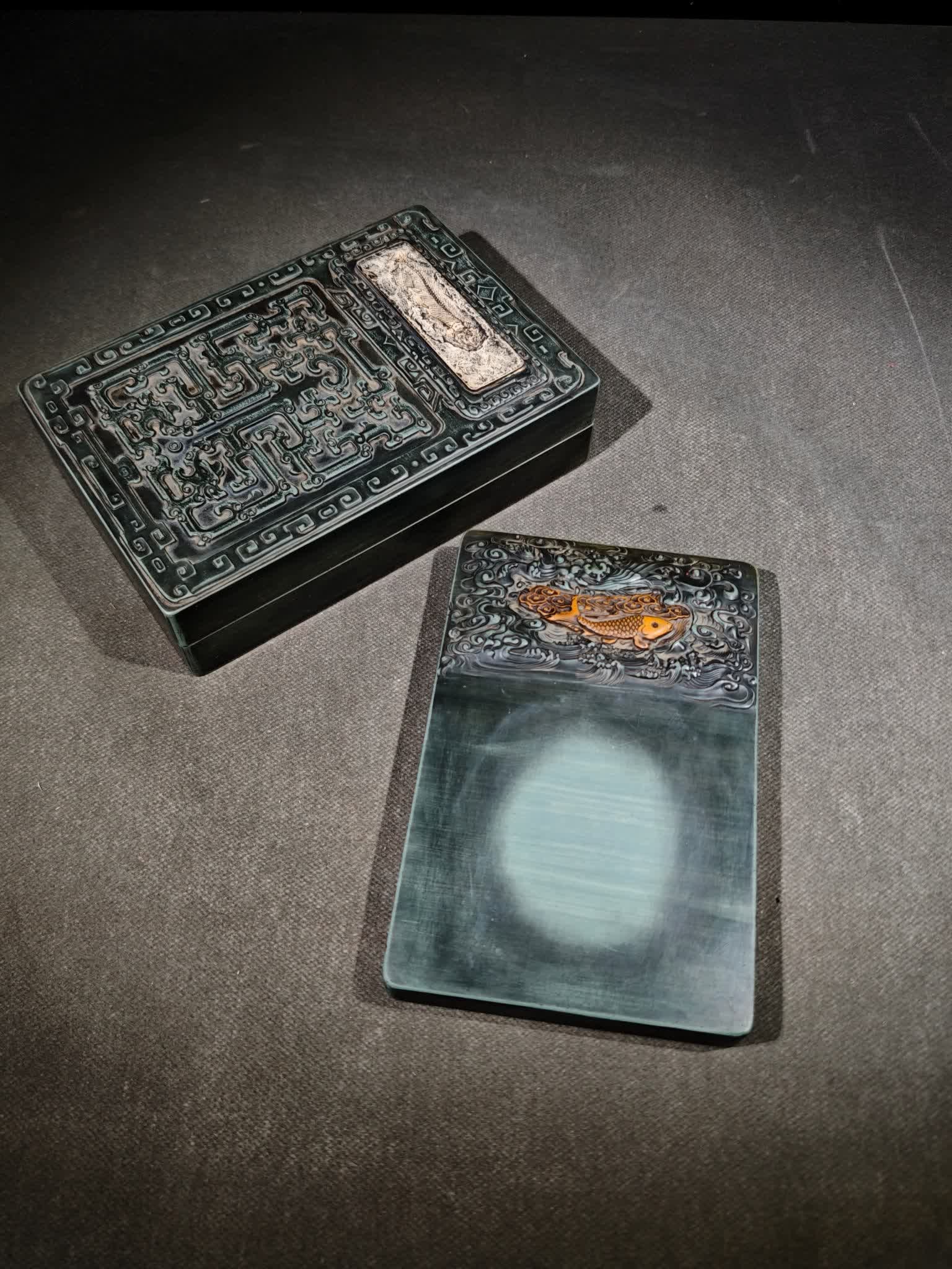 A Qing Dynasty pine stone inlaid fossil inkstone: pine stone inlaid fossil set inkstone, square green stone inkstone, above the relief Yipeng soaring in the sea of clouds; The waves and clouds are all in bas-relief, or in yin carvings to extend aroun