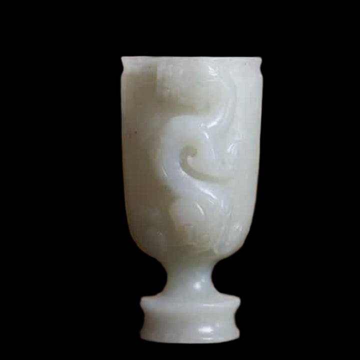 A Qing Dynasty Lilong Valley pattern blue and white jade goblet: Lilong valley pattern blue and white jade goblet cup, this cup is carved from Hetian blue and white jade, the jade quality is warm, the shape is high, the straight shape is beautiful, the cup body is