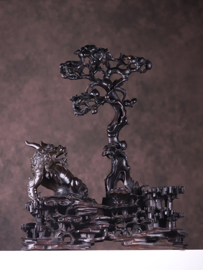 A Qing Dynasty rosewood inlaid copper beast ornament: Qing Dynasty The main body of the rosewood inlaid copper auspicious beast ornament is made of a combination of rosewood carving and copper cast auspicious beast, and the red sandalwood part is carved