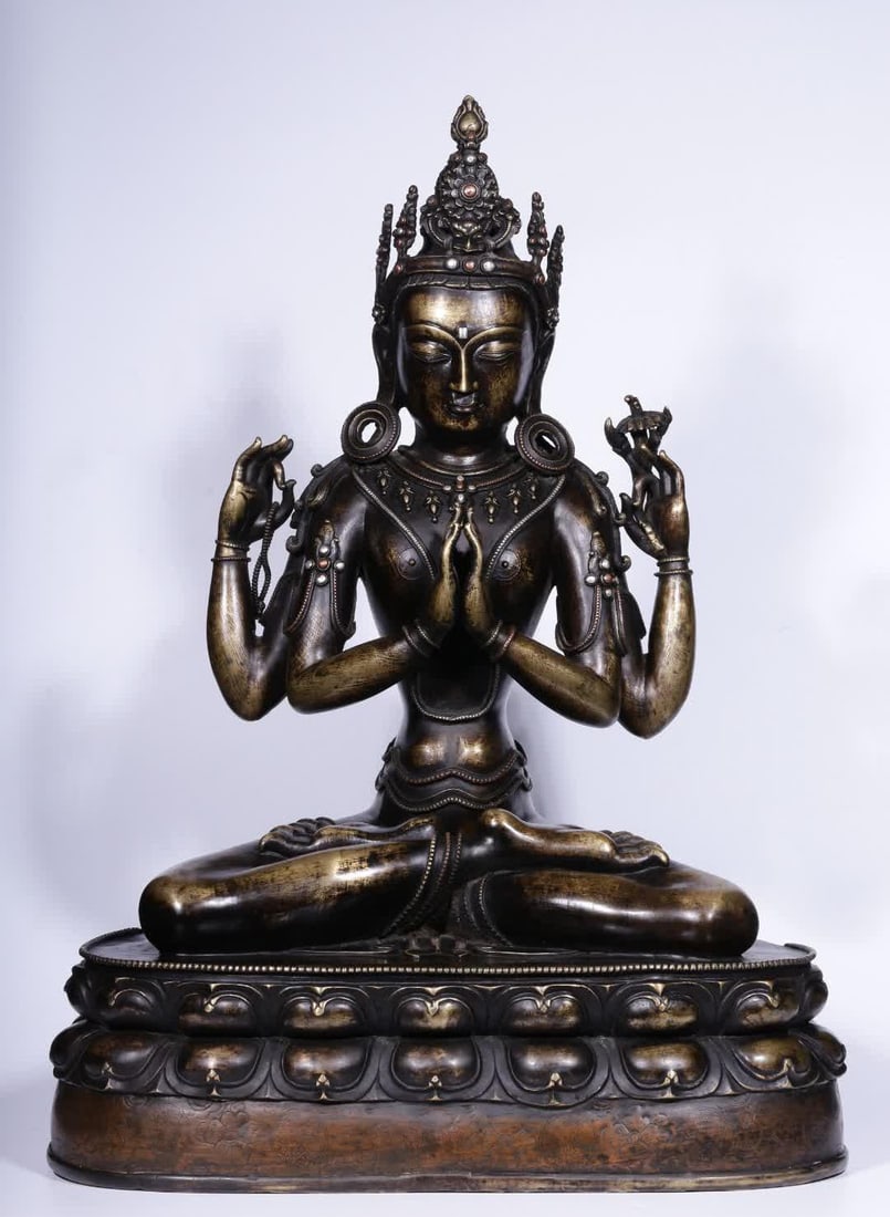 A seated statue of Guanyin with four arms in Qing Dynasty alloy copper and silver (1 of 11)
