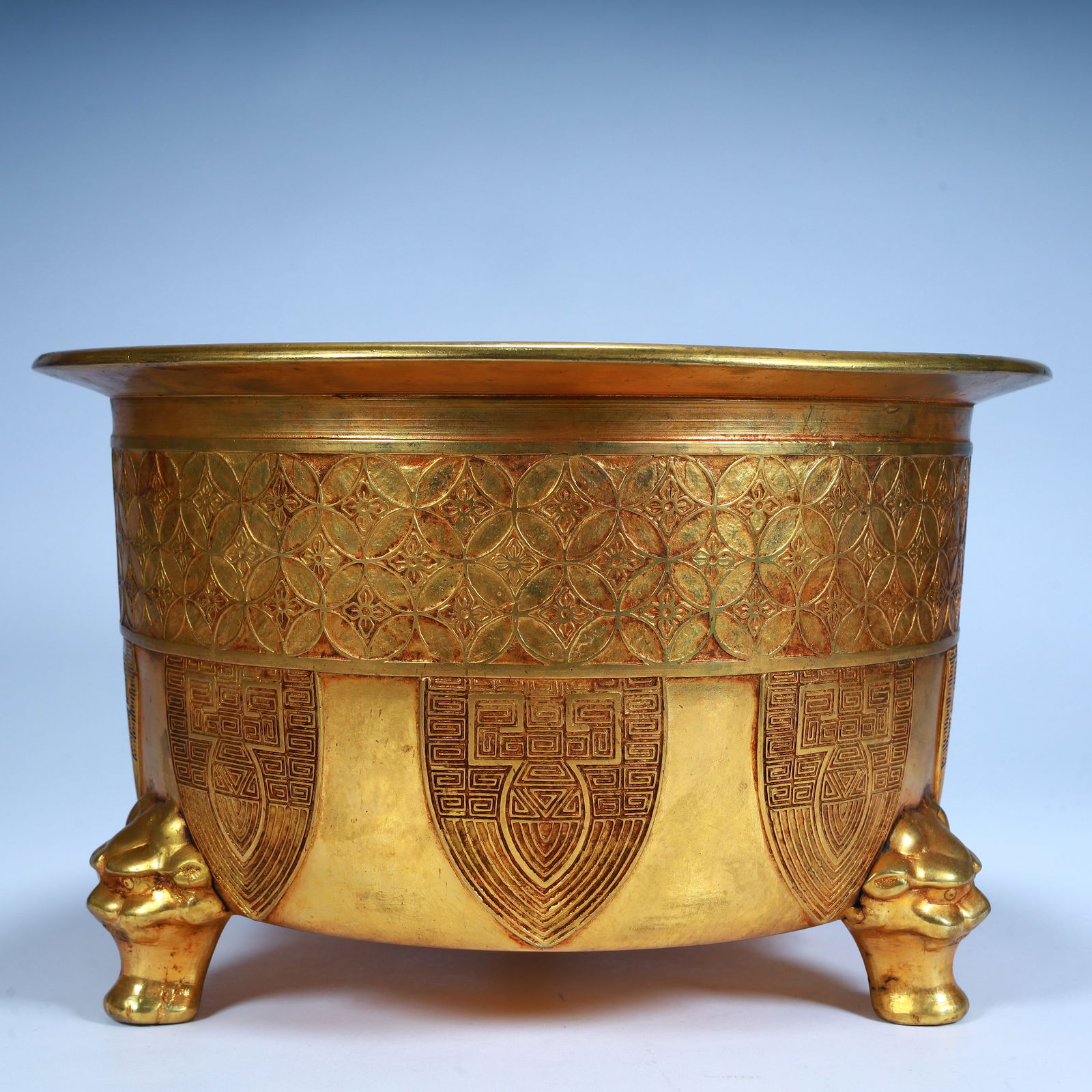A Qing Dynasty copper gilt engraved three-legged furnace, (1 of 9)