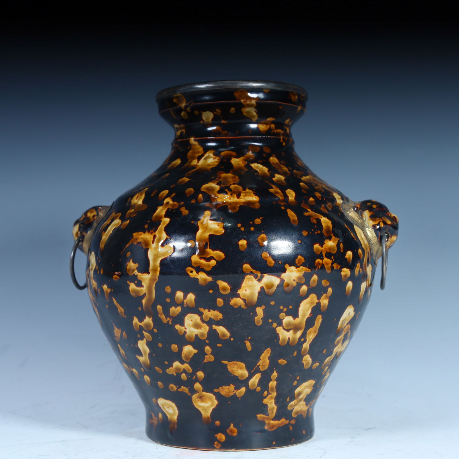 A black-glazed spotted beast ear ring jar: The black glaze colorful beast ear ring jar adopts the black glaze porcelain process, and the glaze surface presents unique color spots, which is formed by the natural flow and blending of glaze durin